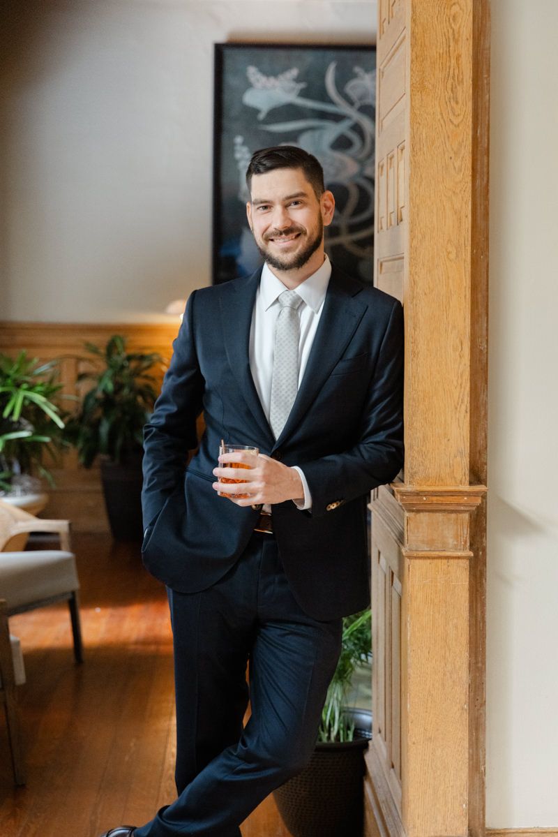 Candid photo of groom getting ready at the historic Jekyll Island Club Hotel, timeless wedding photography with elegant detail.