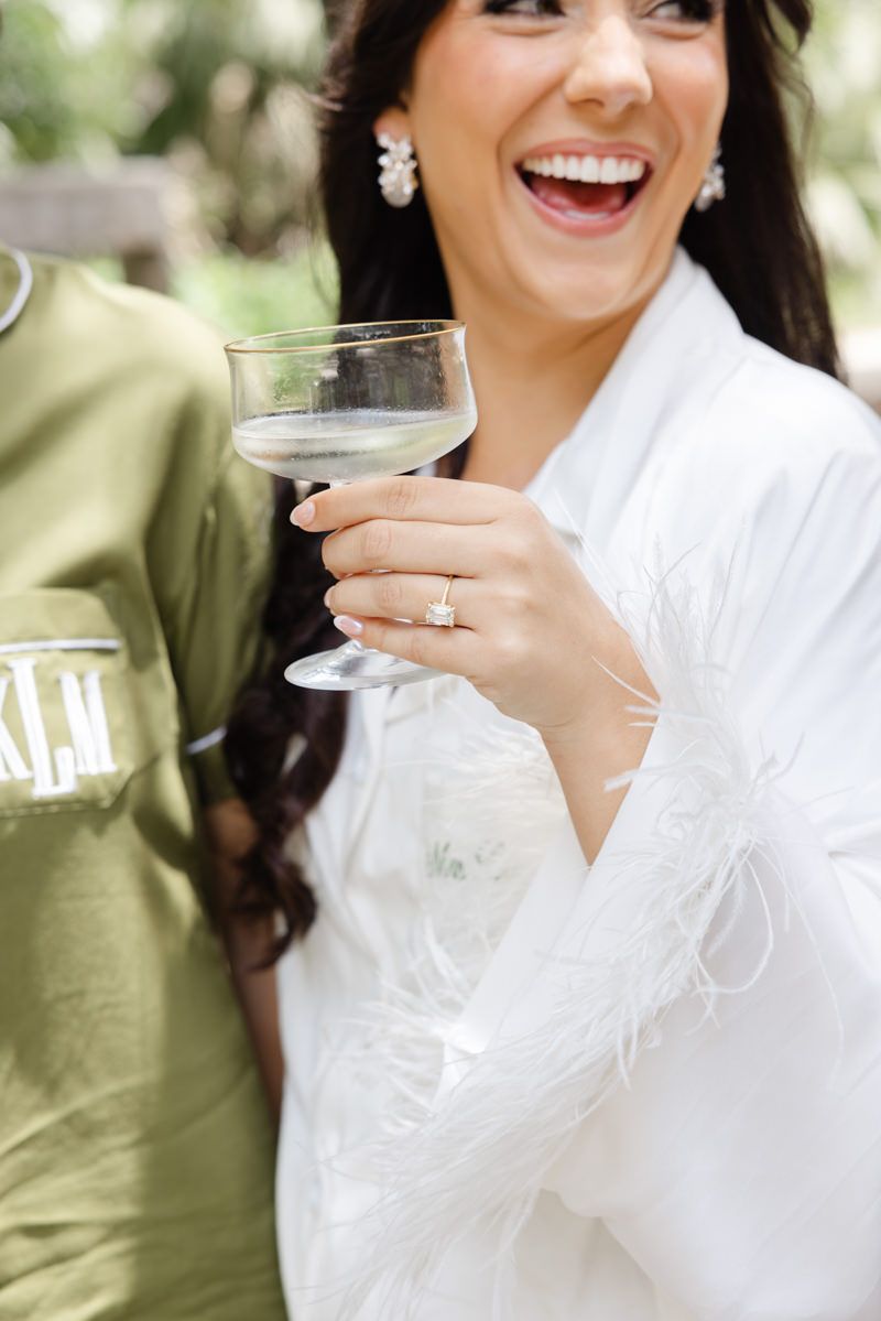 Bride cheers with bridesmaids at Captains Bluff on St. Simons Island, a candid wedding moment captured by photographer in the Golden Isles.