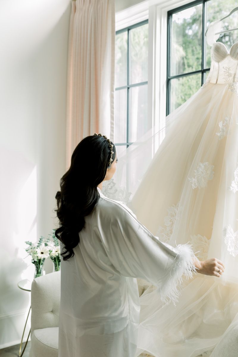 Bride looking at her wedding dress at Forbes Farm, St. Simons Island luxury wedding photographer capturing chic bridal inspo.