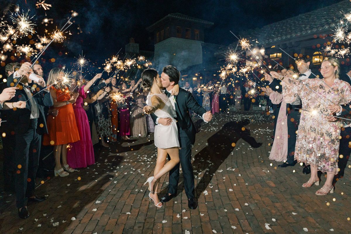 Bride and groom kiss during a dramatic sparkler exit at Frederica Golf Club on St. Simons Island, captured by wedding photographer.