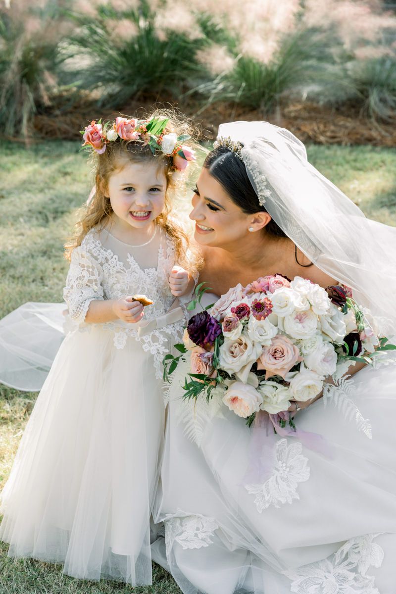 Bride and flower girl holding bouquets at St. Simons Island wedding, candid Georgia wedding photographer photo inspo.