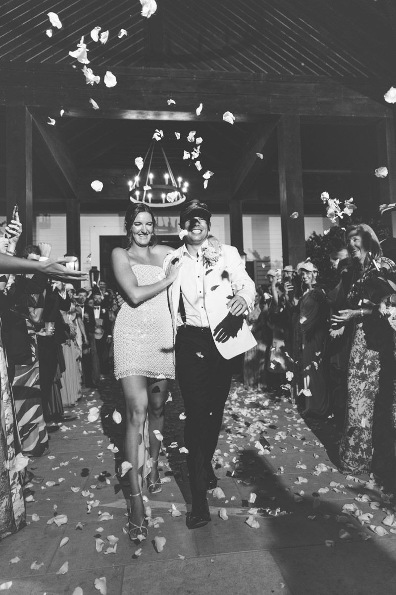Editorial-style grand exit of bride and groom with flower petals at Forbes Farm on St. Simons Island, by wedding photographer.