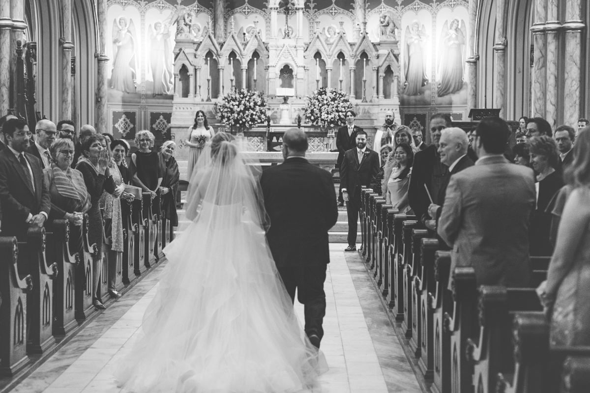 Wedding ceremony at St. John’s Basilica Cathedral in Savannah, Georgia, captured in a film-inspired editorial style by photographer.