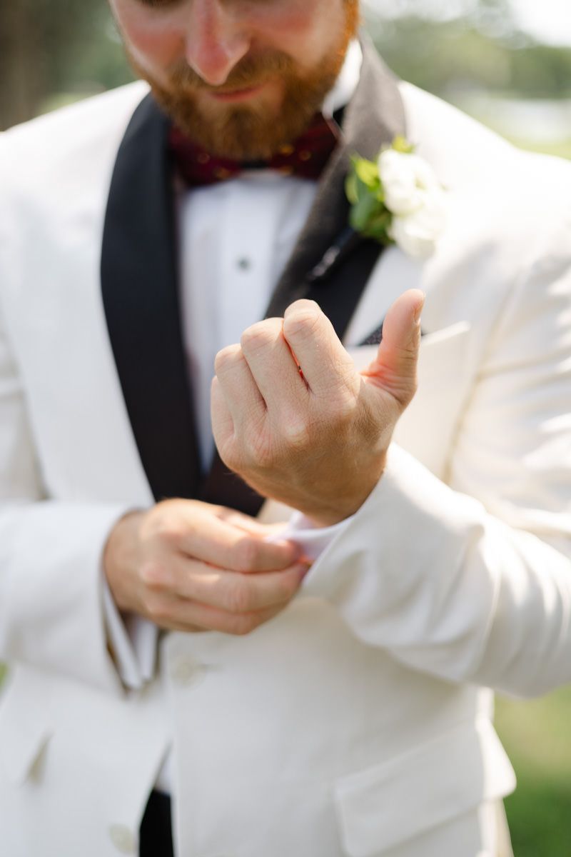 Editorial film-style photo of groom buttoning his jacket at Sea Island, captured by wedding photographer in the Golden Isles.