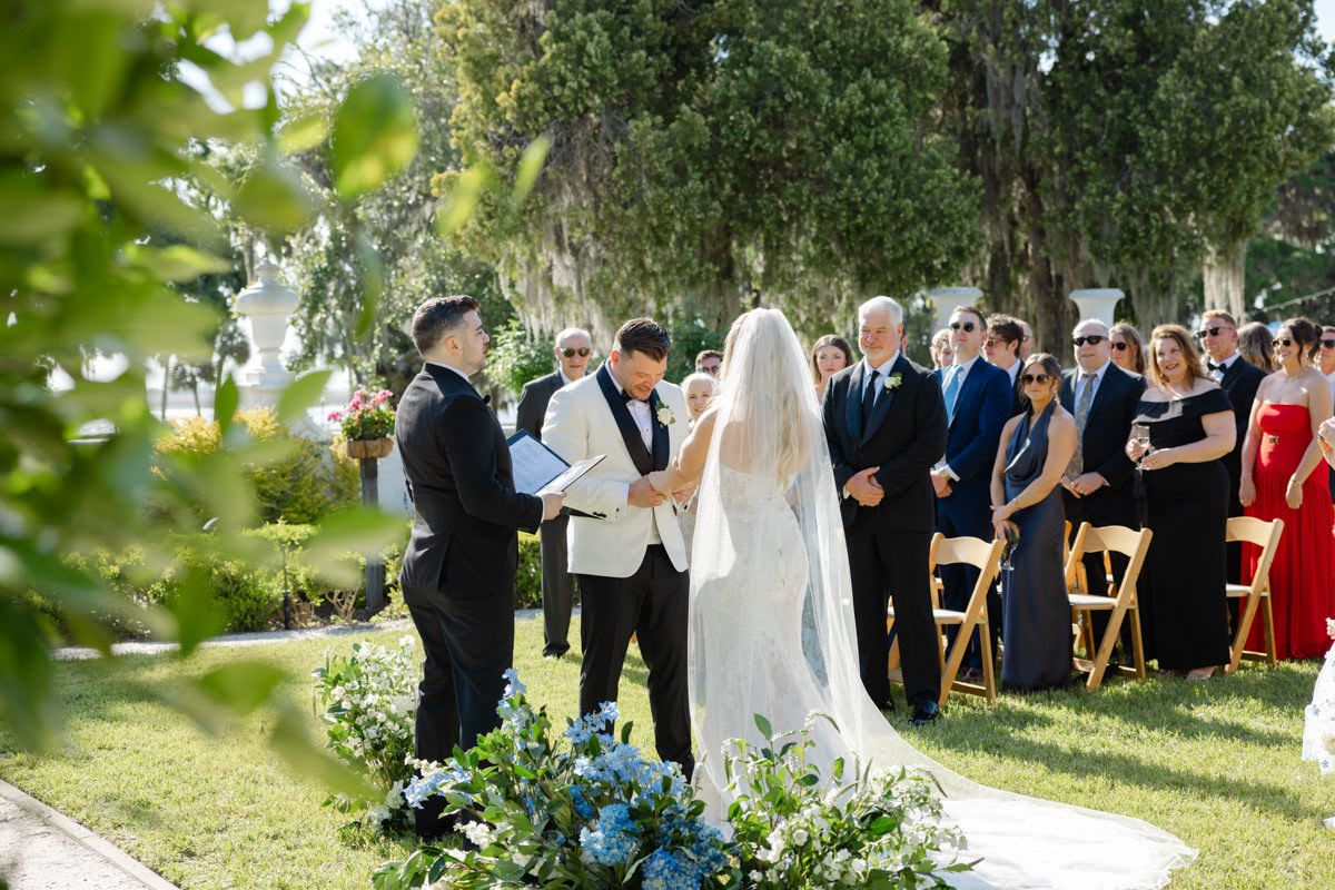 Wedding ceremony in the garden at Crane Cottage, Jekyll Island Club Resort, during a high-end luxury event, captured by photographer.