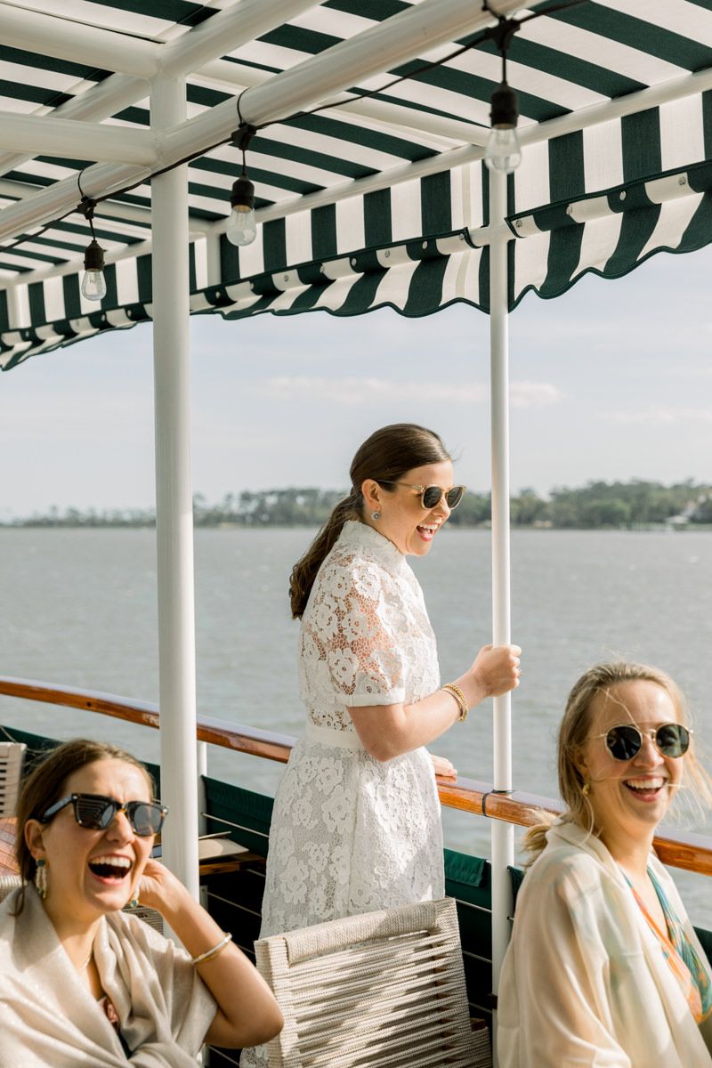 Candid photo of bride during a Sea Island river cruise rehearsal dinner, captured in a relaxed moment by wedding photographer.