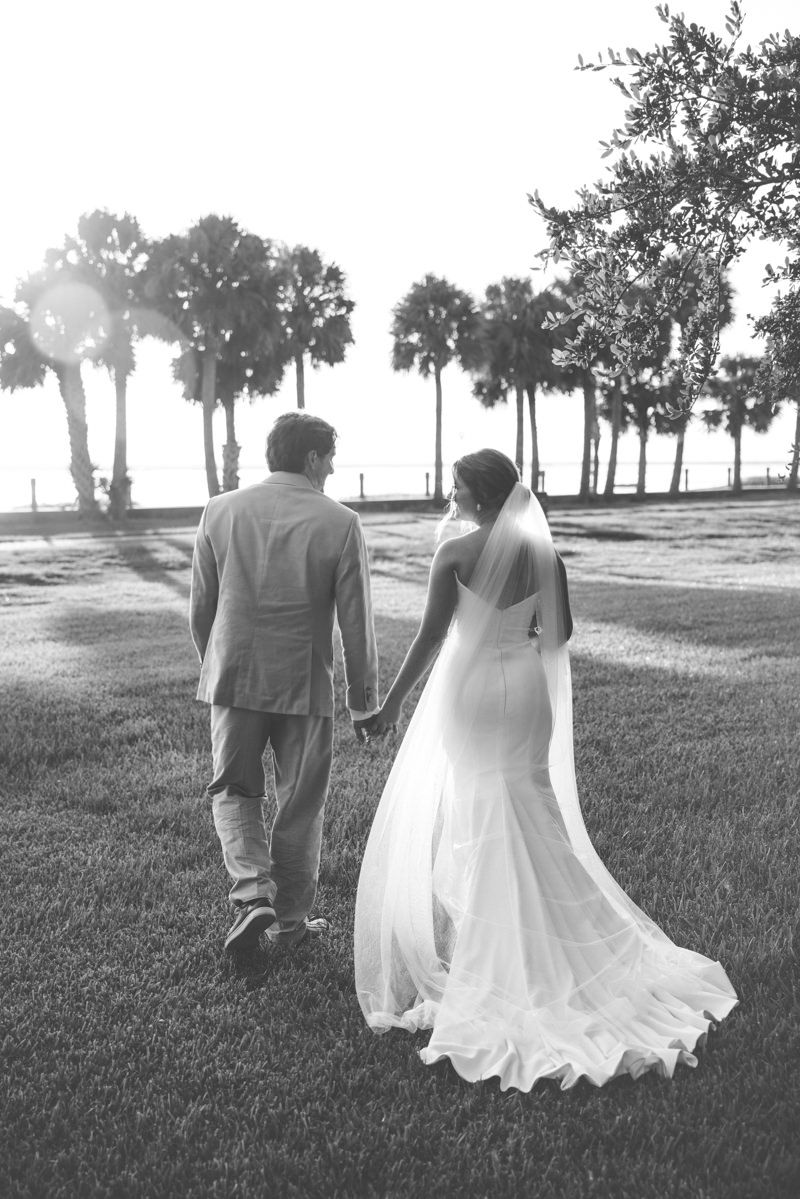 Modern photo of elegant bride and groom walking along the riverfront at Jekyll Island, captured by wedding photographer in Georgia.