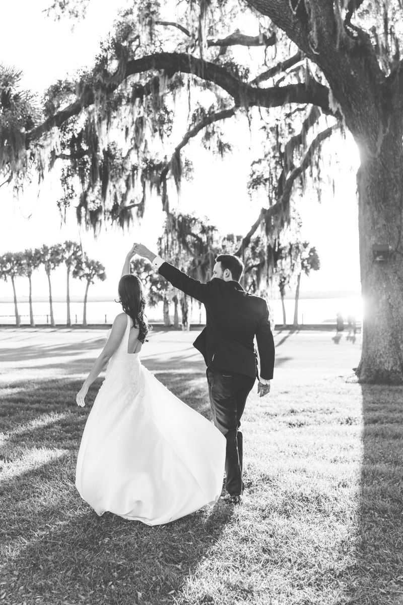 Black-and-white candid of bride and groom twirling at Jekyll Island wedding, editorial chic photography with romantic, aesthetic vibes.