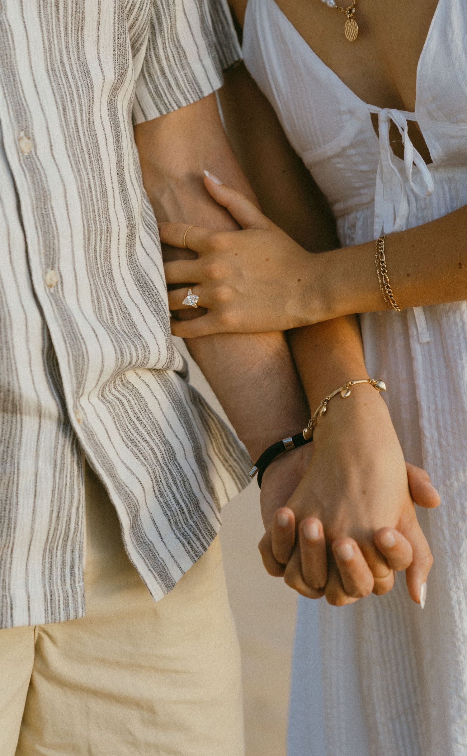 Close-up of intertwined hands showing affection and intimacy.
