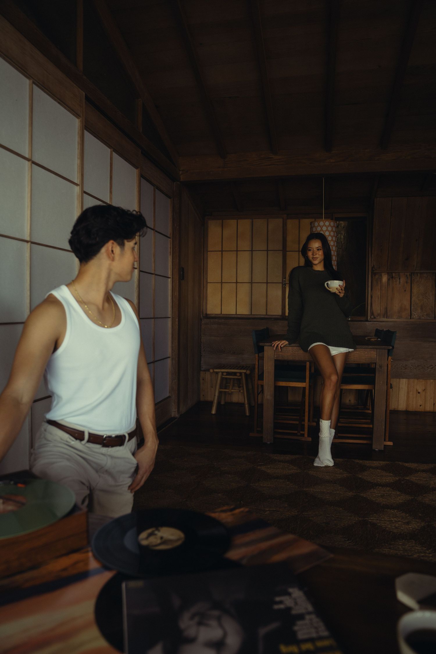 Two people in casual wear with record player in Japanese-style room.