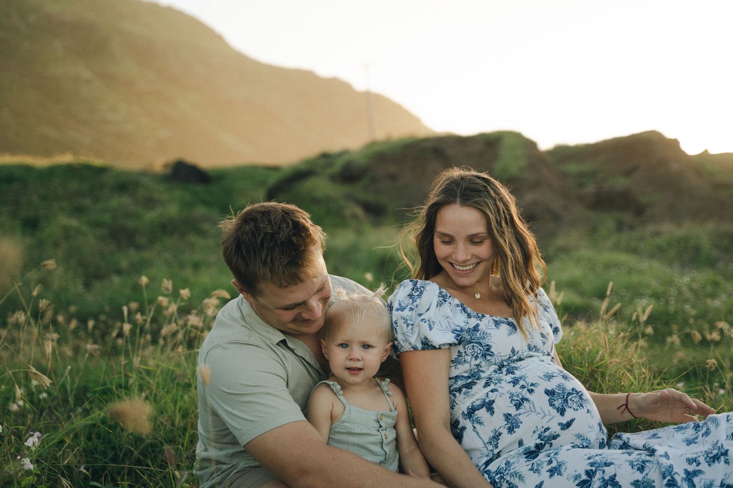 Family sharing tender moments together in a scenic mountain setting at sunset.