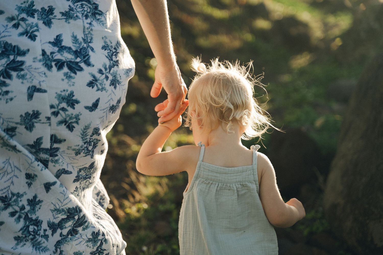 Family playing together in a sunlit meadow with wildflowers.