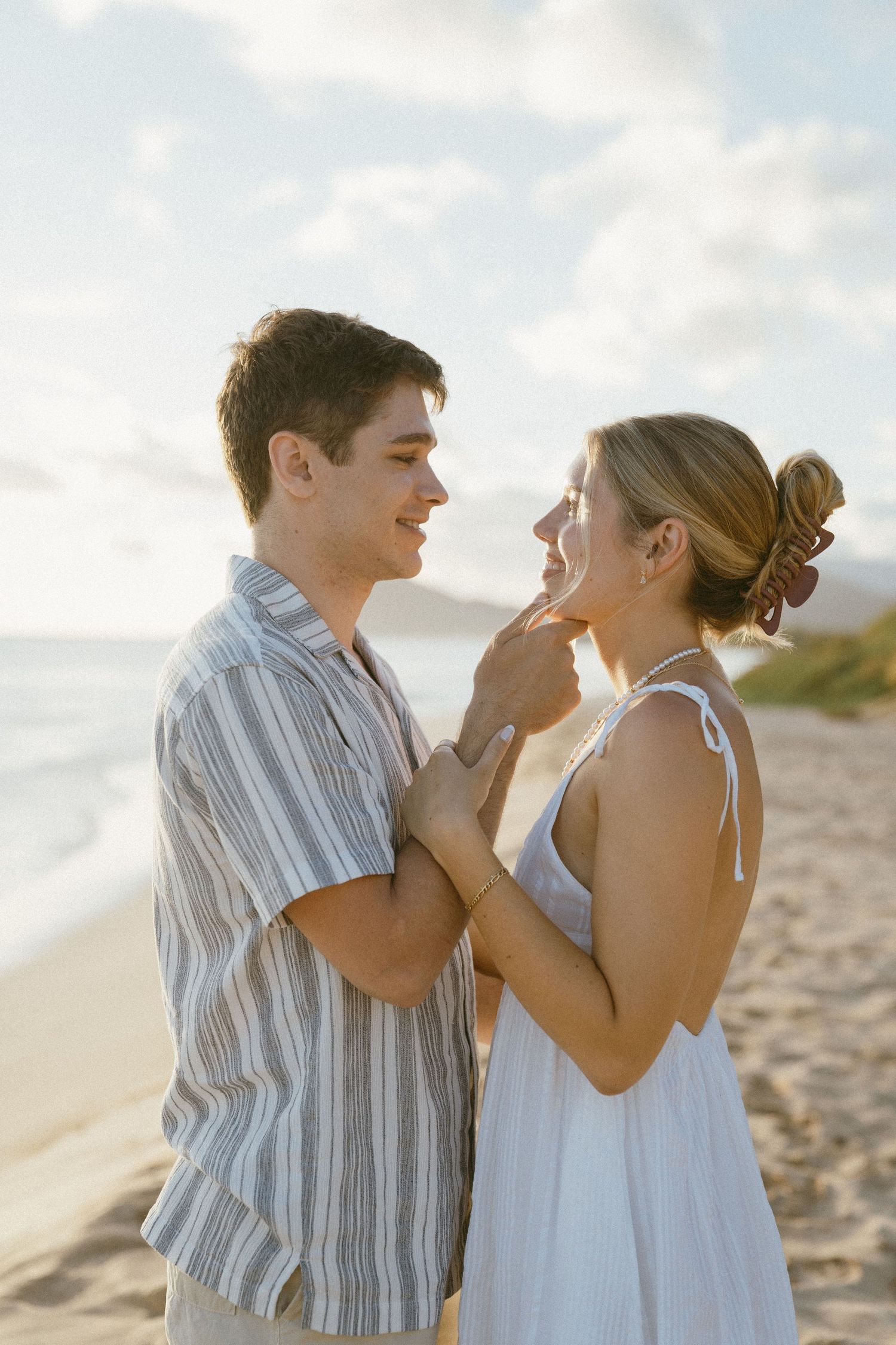 A romantic moment between two people on a sunny beach.