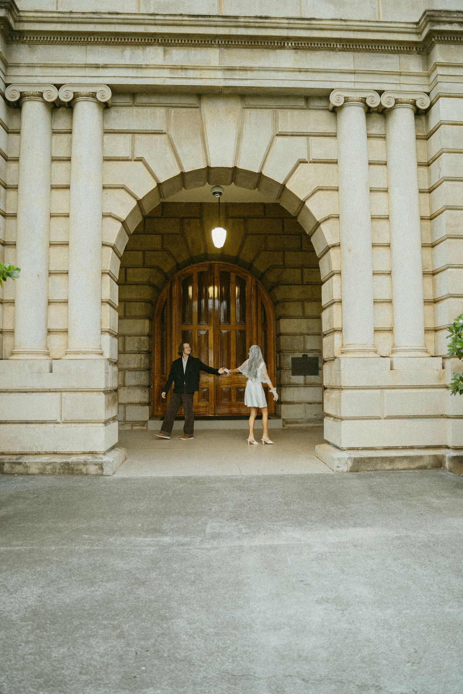 Classical stone archway entrance with ornate architectural details and warm lighting.