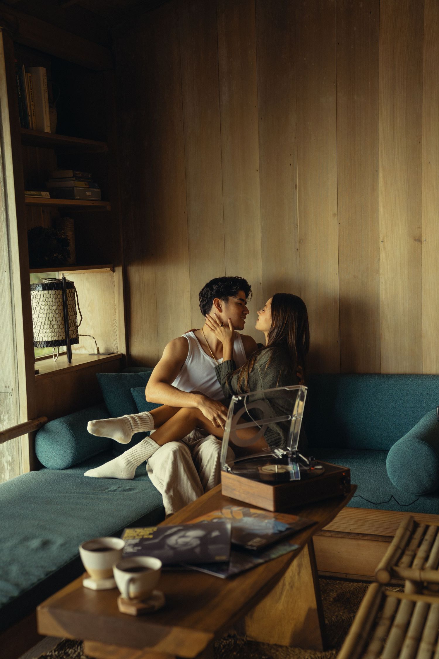Couple listening to vinyl records together on vintage turntable in intimate setting.