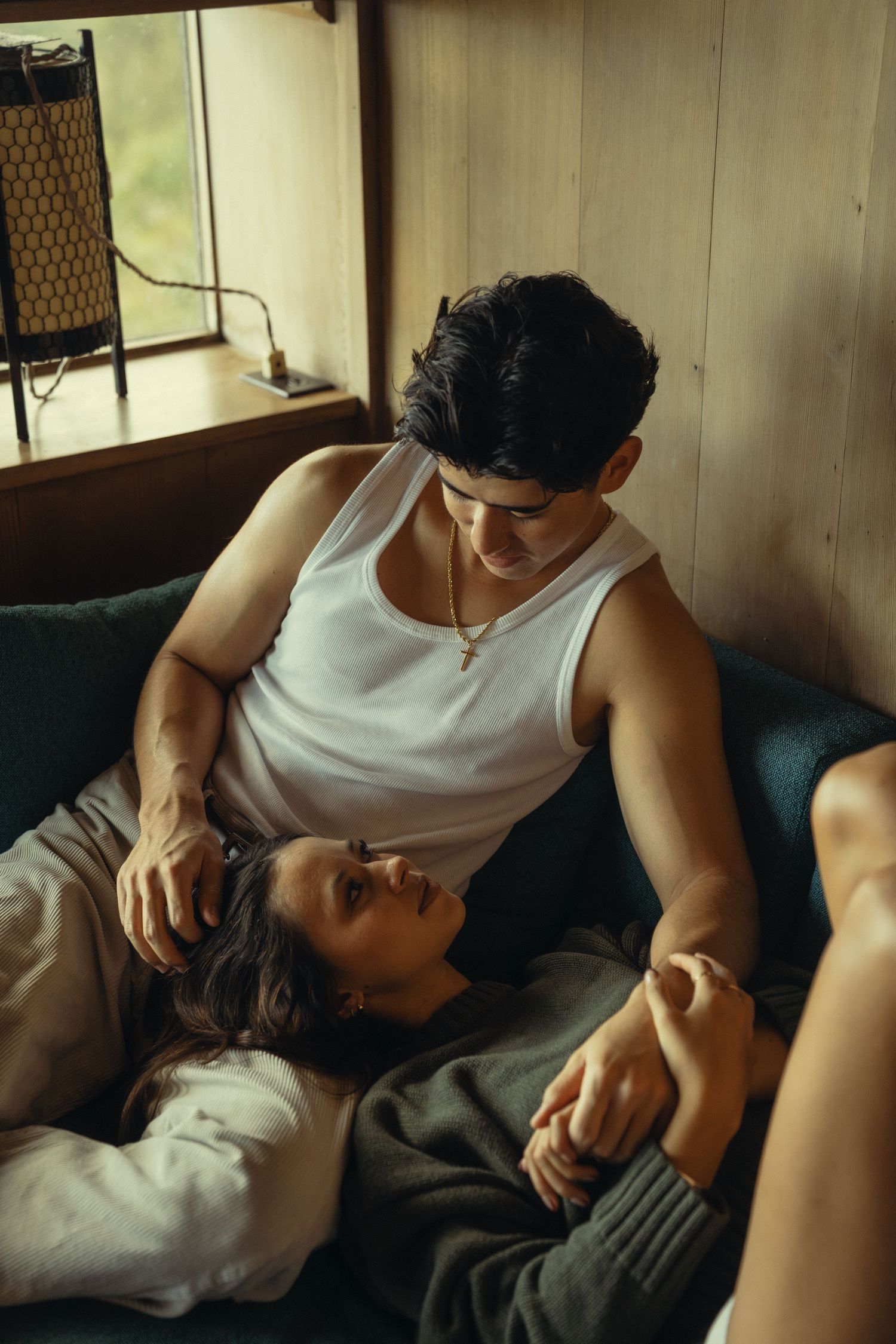 Couple relaxing together on blue couch in cozy indoor setting.