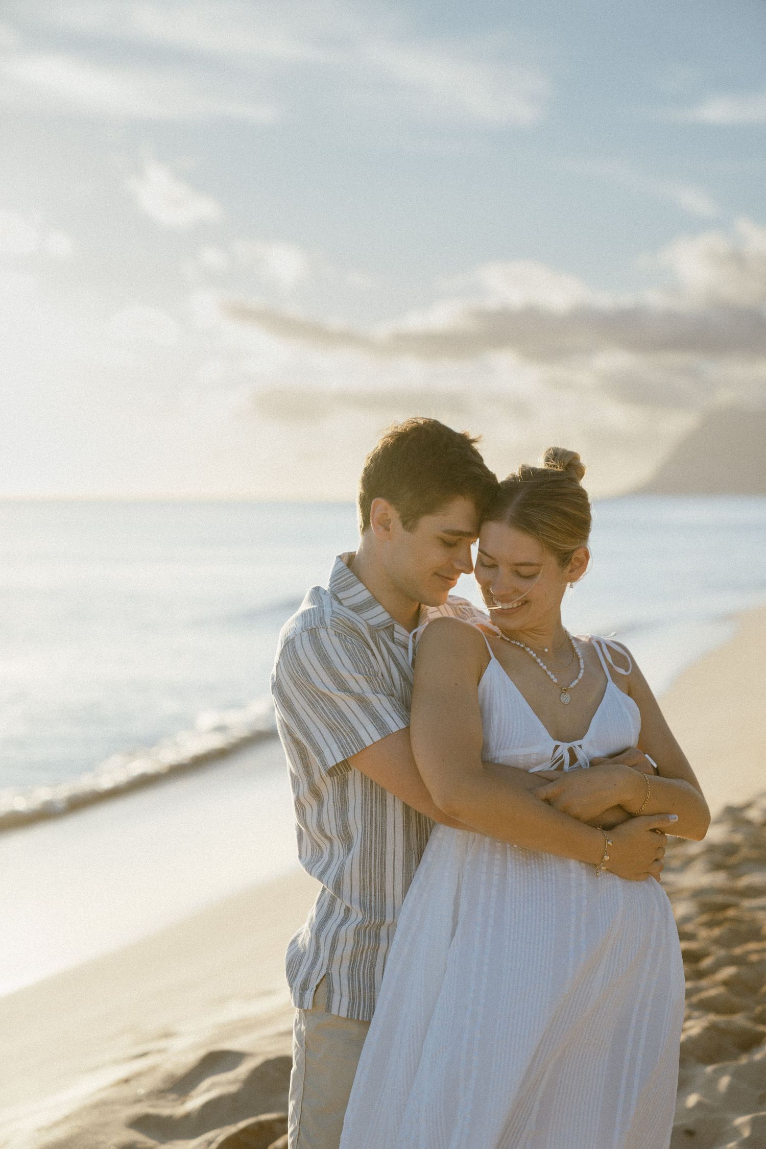 A romantic beach proposal moment captured during golden hour.