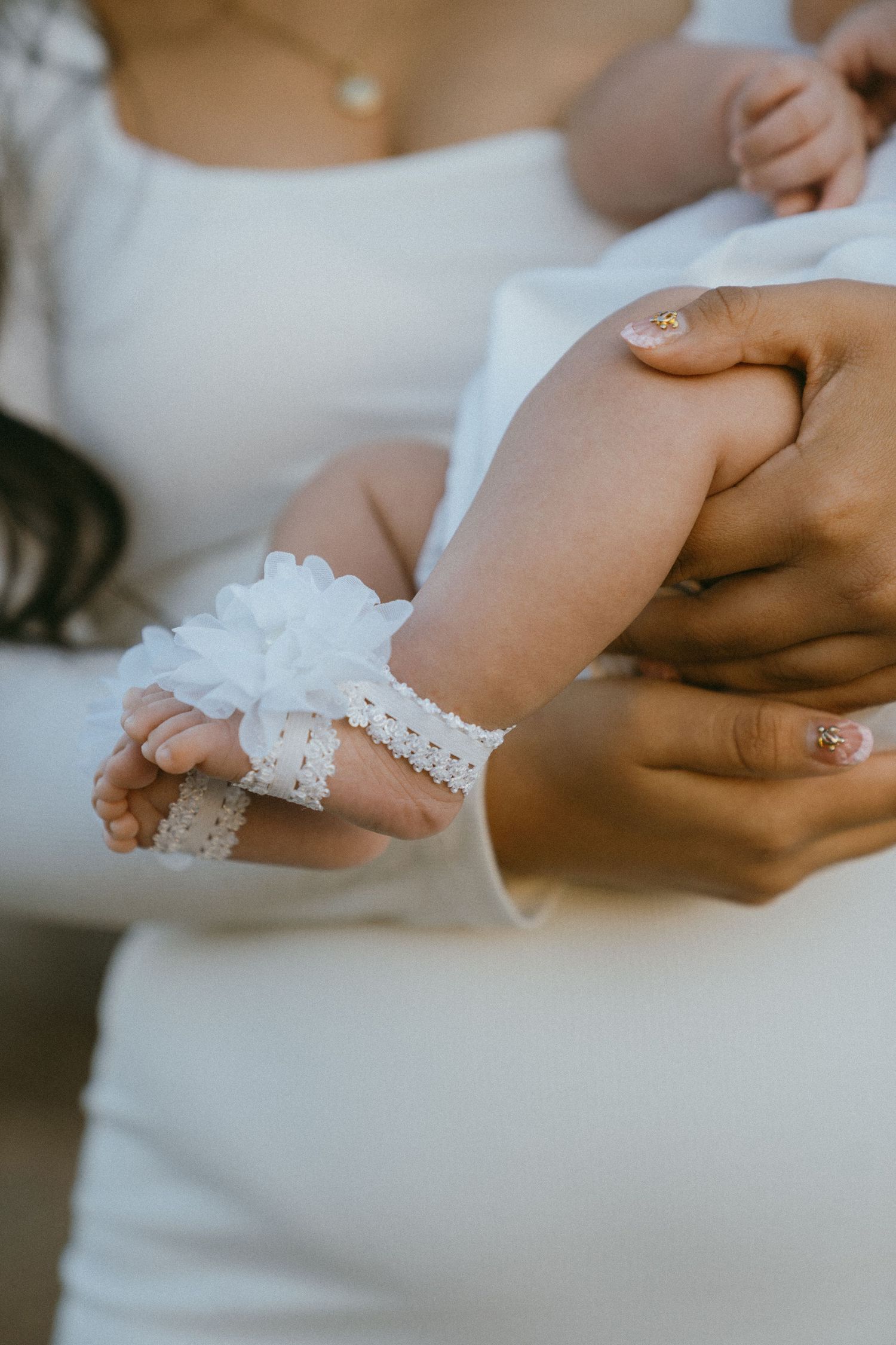 Close-up of hands with delicate lace details against a white background.