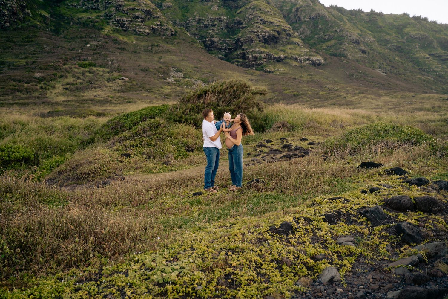 Distant view of couple walking along scenic mountain path at sunset.