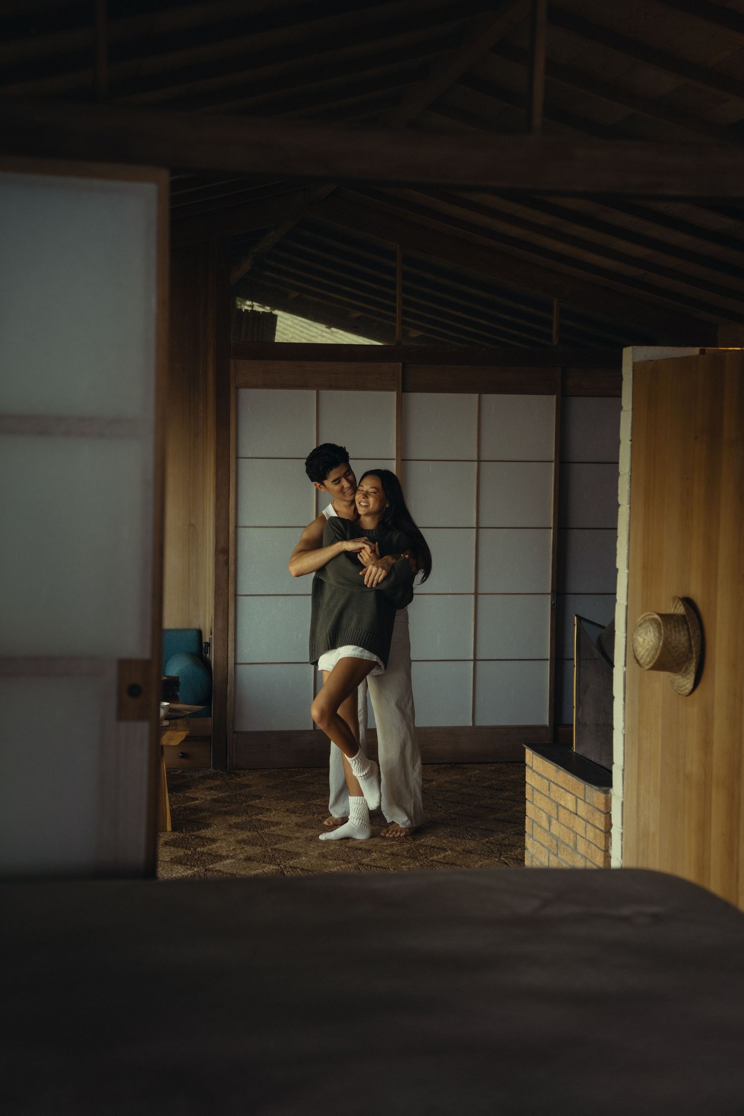 Dancing couple in casual wear inside traditional Japanese-style room.