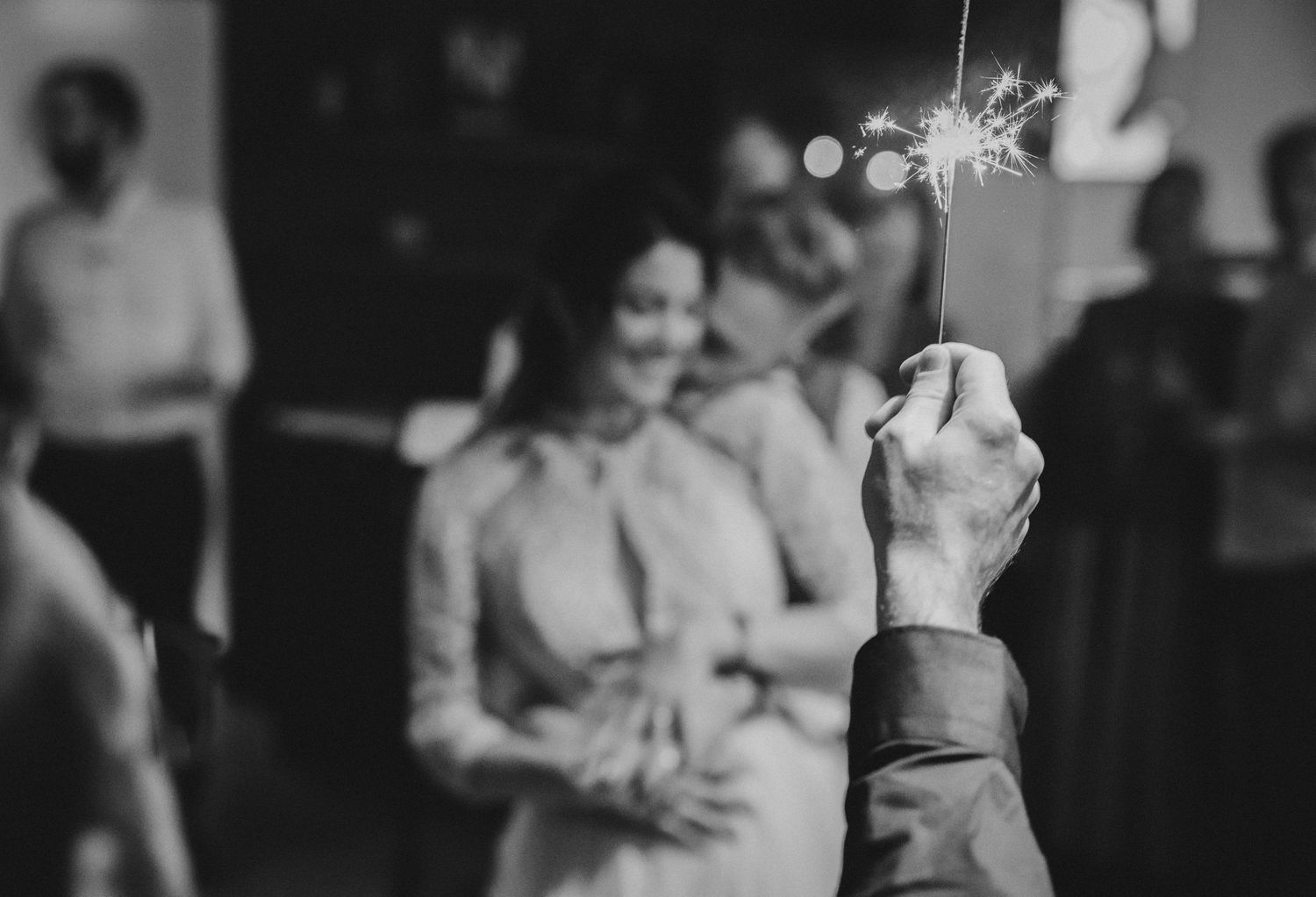 Silhouettes of wedding guests dancing at an evening reception.