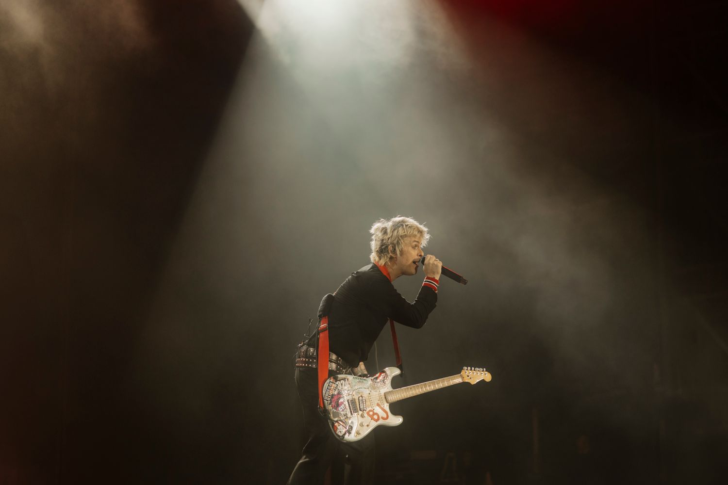 Billie Joe Armstrong of Green Day in a dramatic spotlight. High-contrast live music photography by a Melbourne photographer.