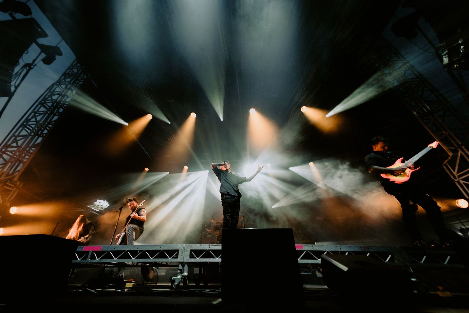Wide angle stage shot of Lorna Shore performing with dramatic white and orange light beams, Melbourne heavy metal concert photography.