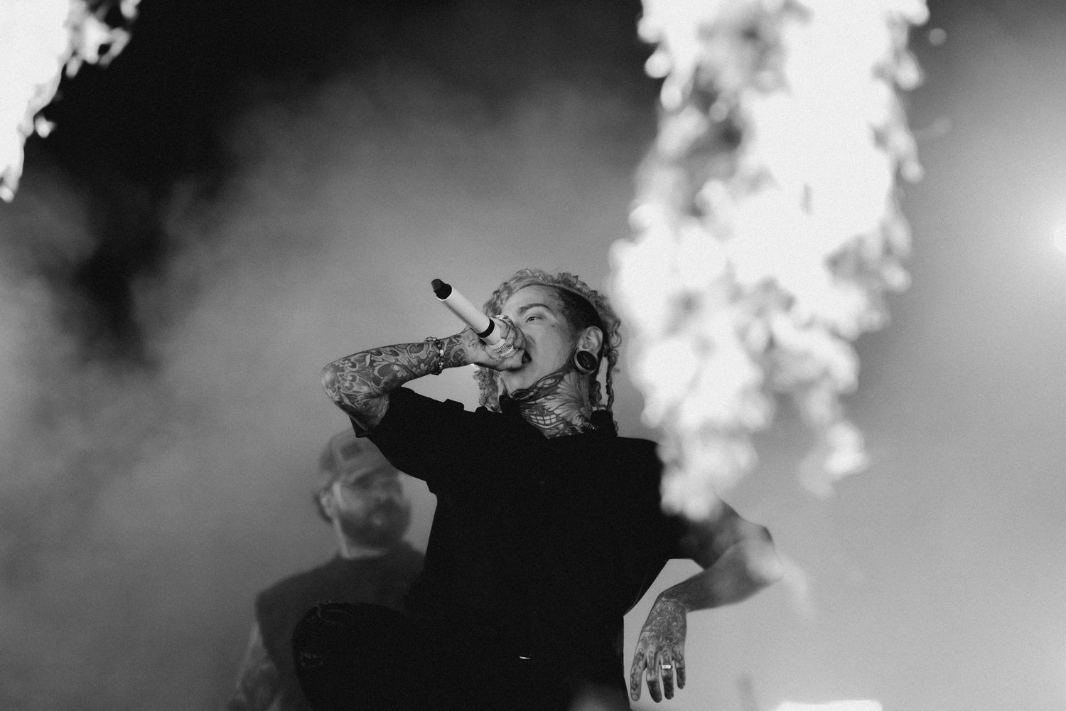 Black and white candid of Lorna Shore vocalist Will Ramos screaming into a microphone during a pyrotechnic stage show. Melbourne Good Things