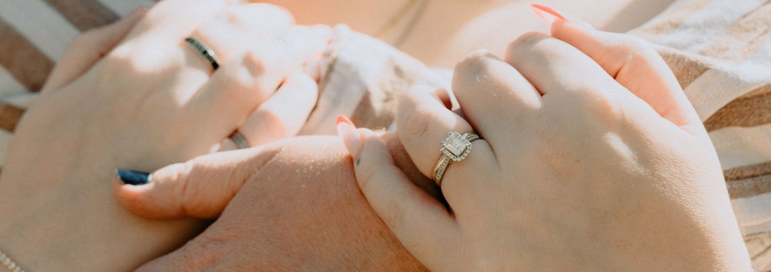 Detailed close-up of a diamond engagement ring during a couple's photoshoot, highlighting elegant bridal jewellery and connection.