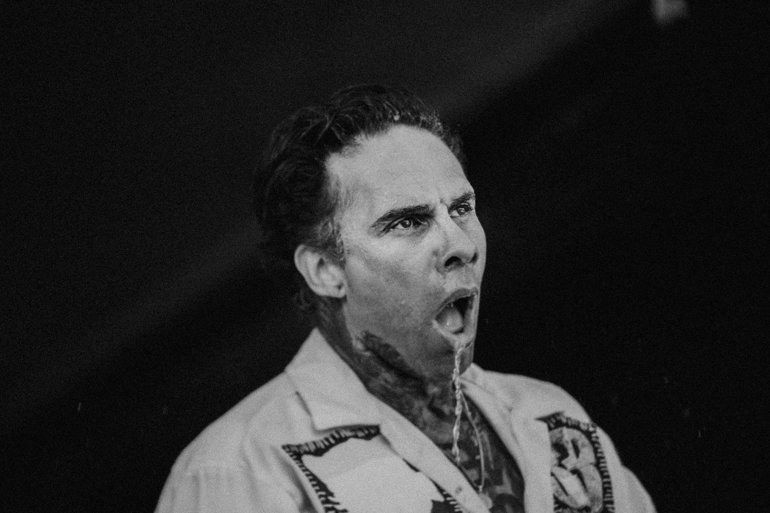 Gritty black and white close-up of Fever 333 vocalist Jason Aalon Butler mid-performance, high-energy live music portrait.