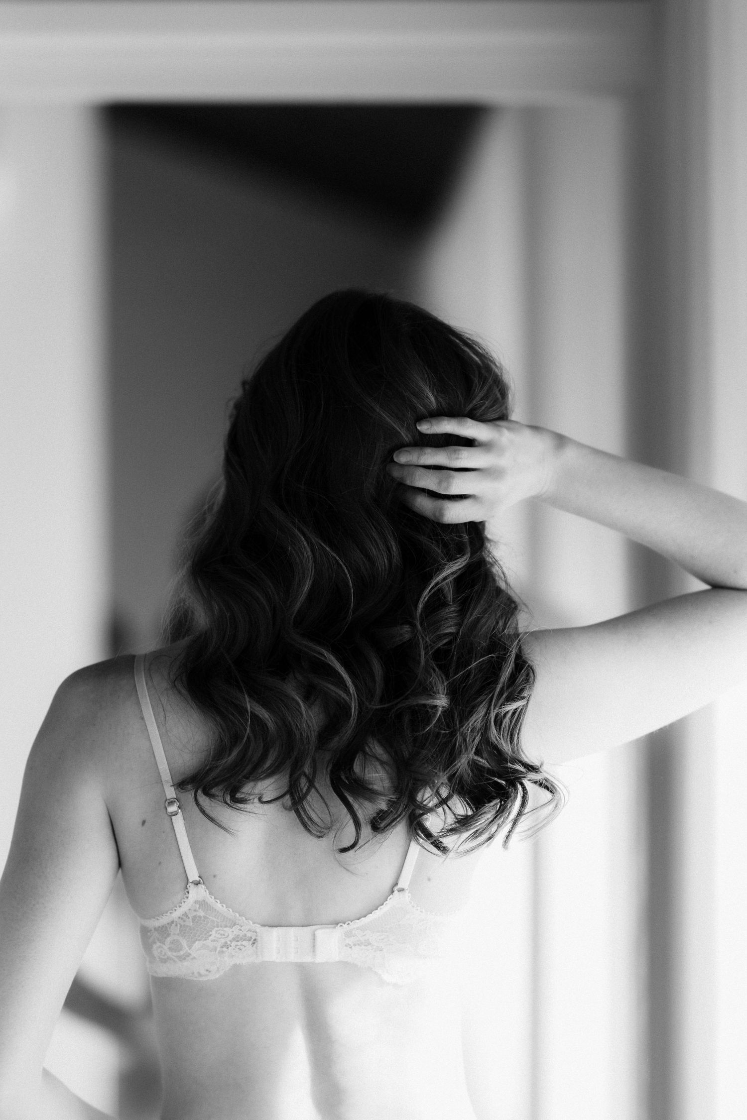 Black and white bridal boudoir photography in Melbourne featuring a bride with wavy hair in lace lingerie.