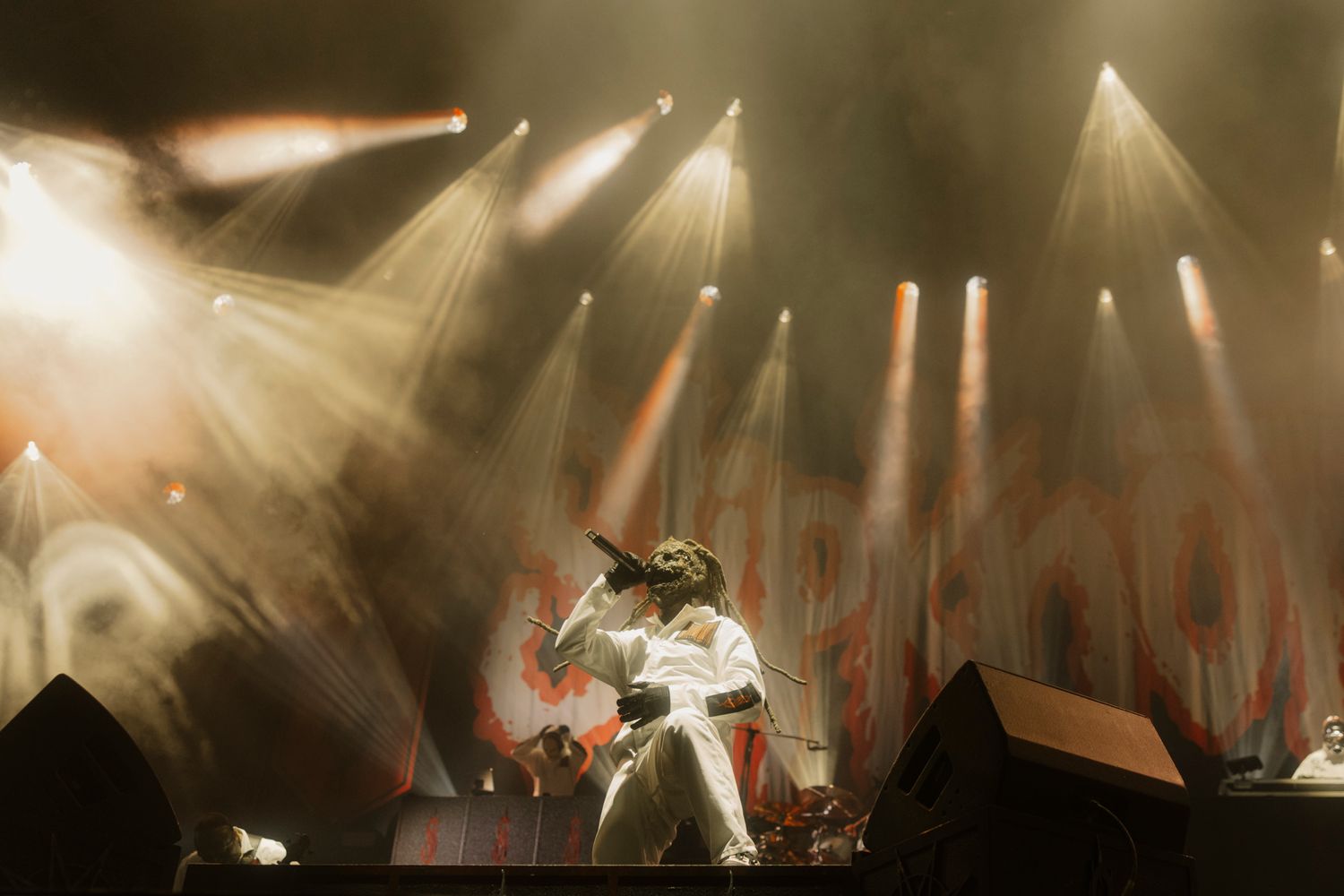 Slipknot lead singer Corey Taylor performing in a white jumpsuit under bright spotlights at Knotfest Australia.
