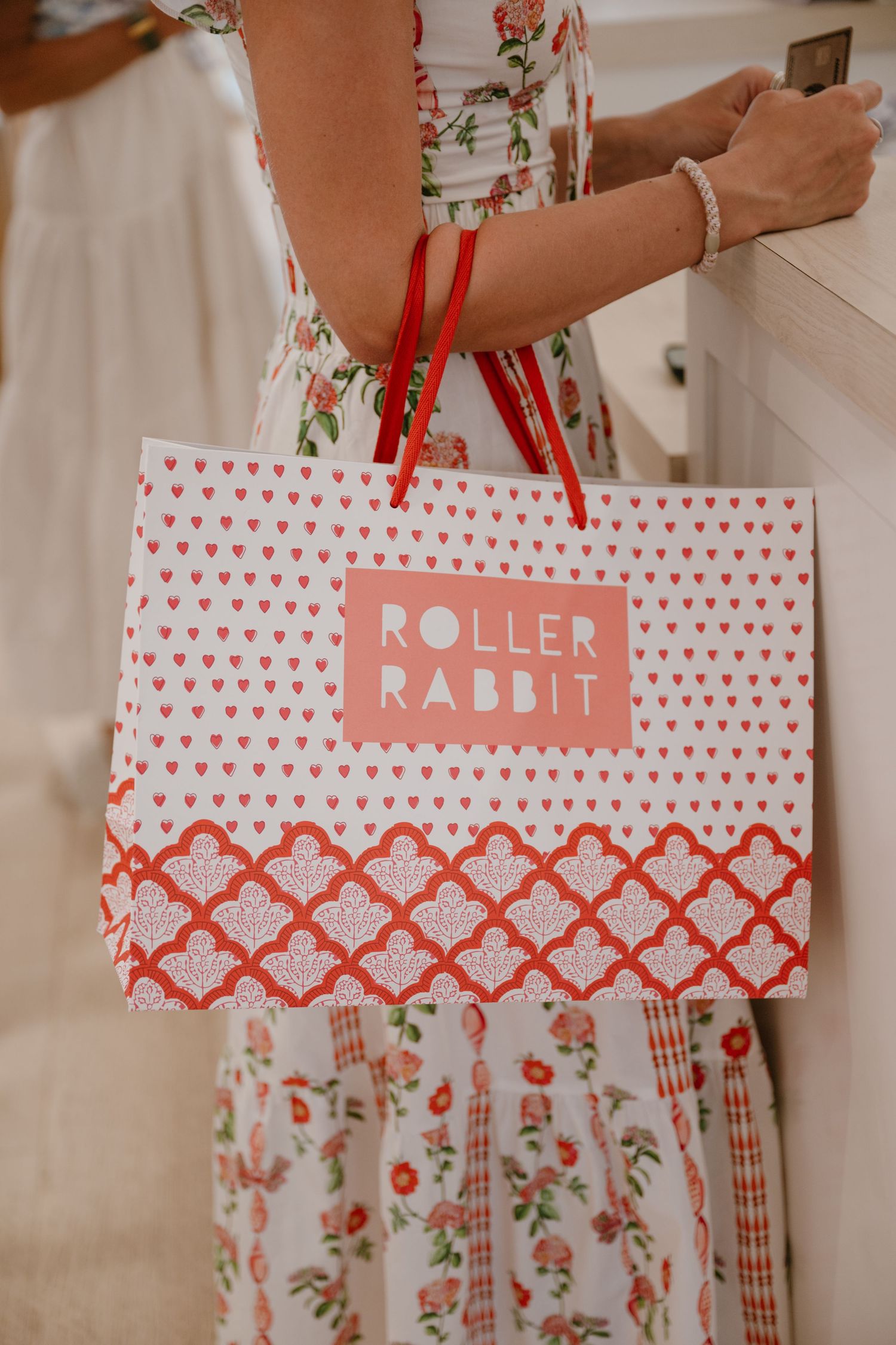Roller Rabbit branded shopping bag with red handles featuring heart and floral pattern design.