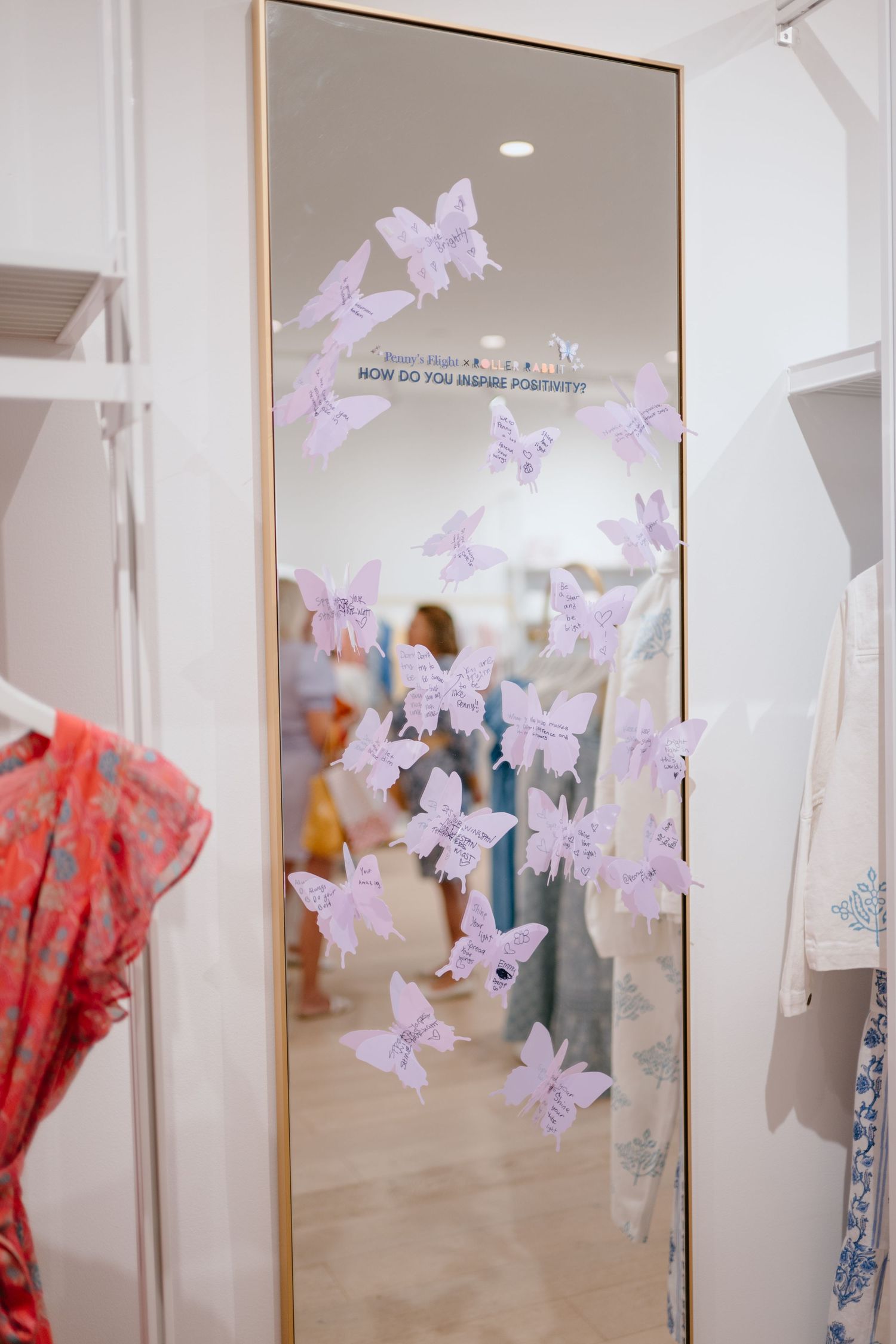 Gold-framed mirror decorated with purple paper butterflies asking how do you inspire positivity.