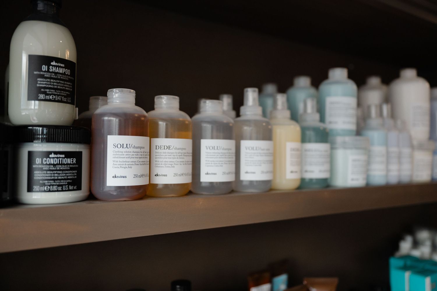 Shelves of Davines hair care products including shampoos and conditioners in a professional salon.
