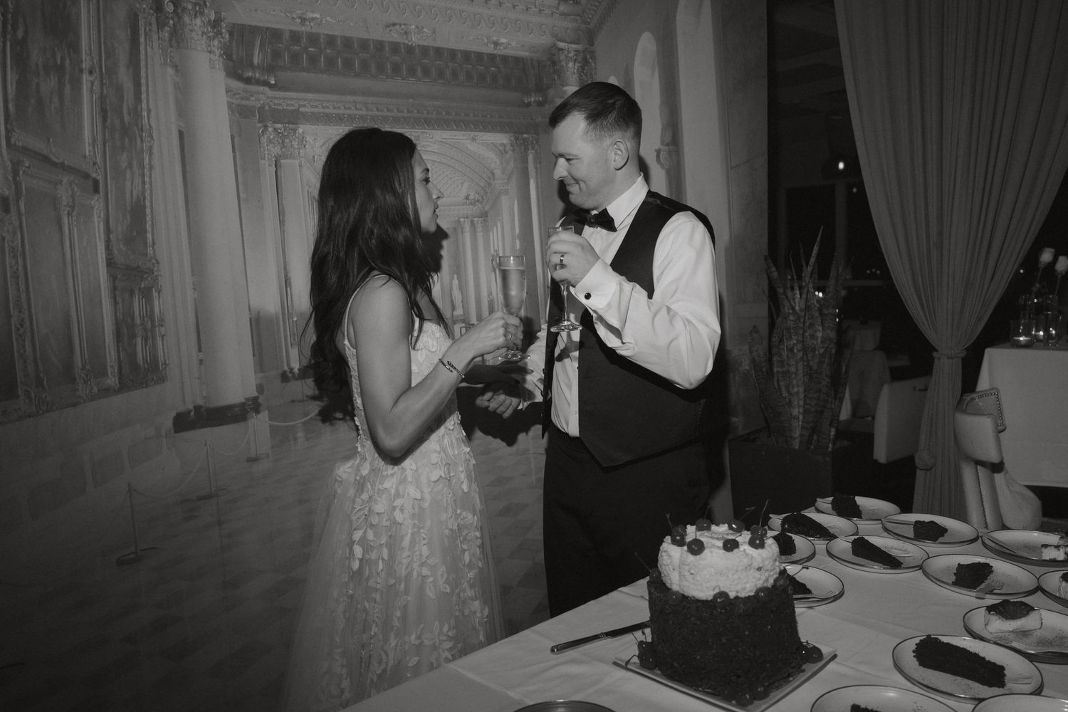 Bride and groom cutting their wedding cake together at a reception venue.