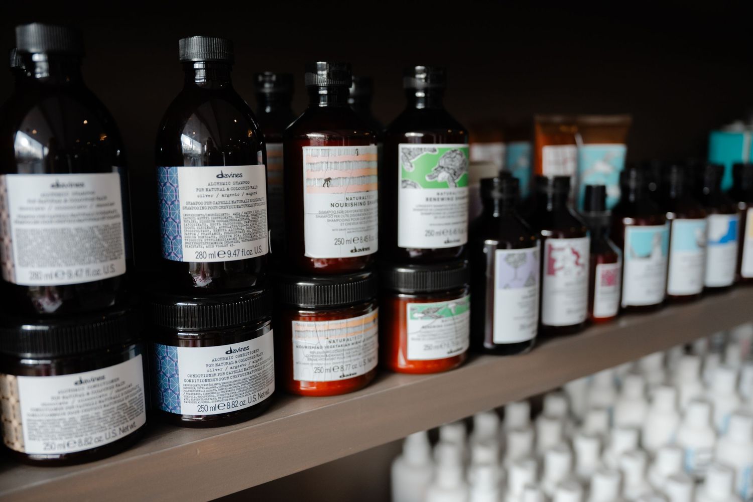 Assorted professional hair care products displayed on salon retail shelves.