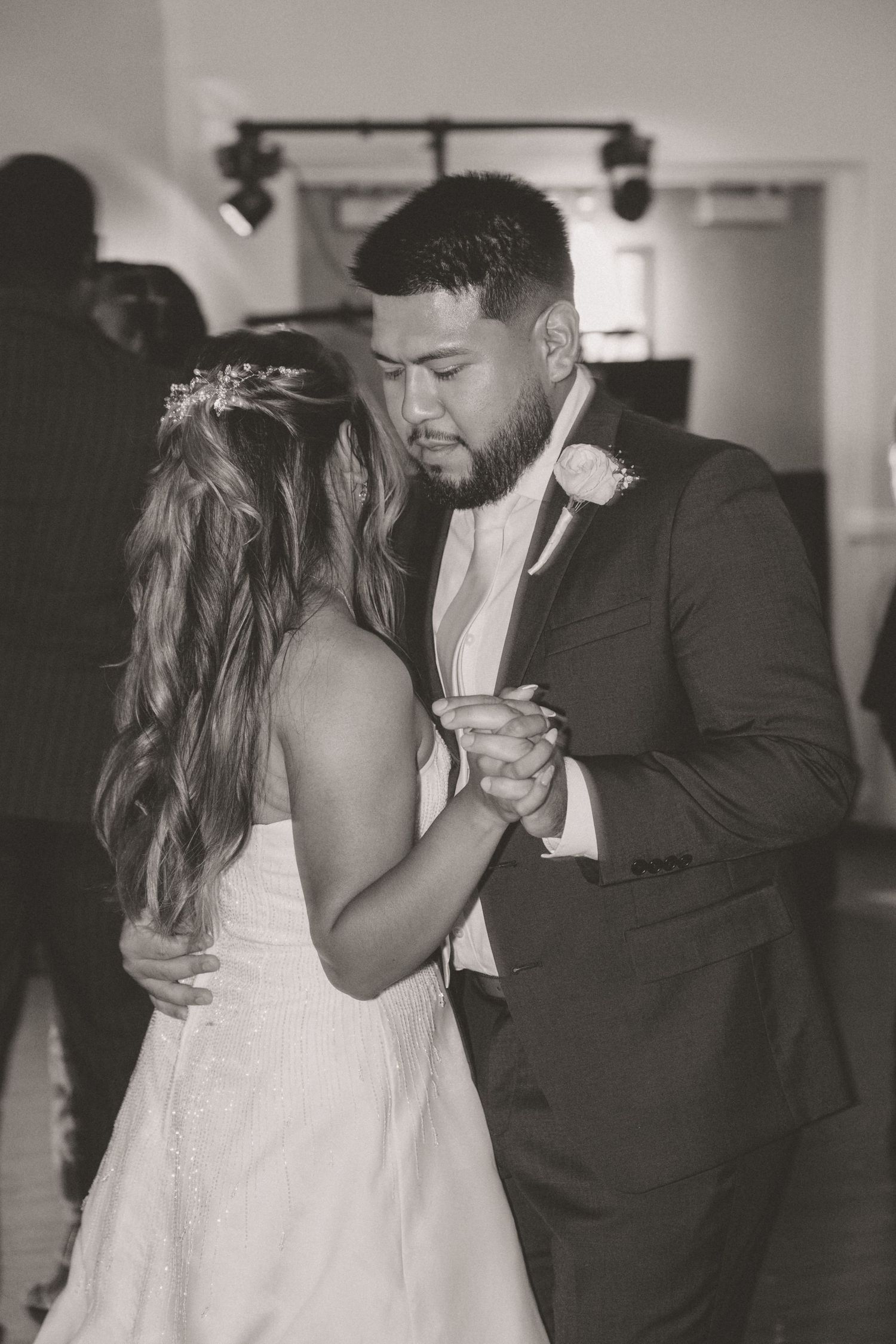 Bride and groom share their first dance in a black and white wedding reception photo.