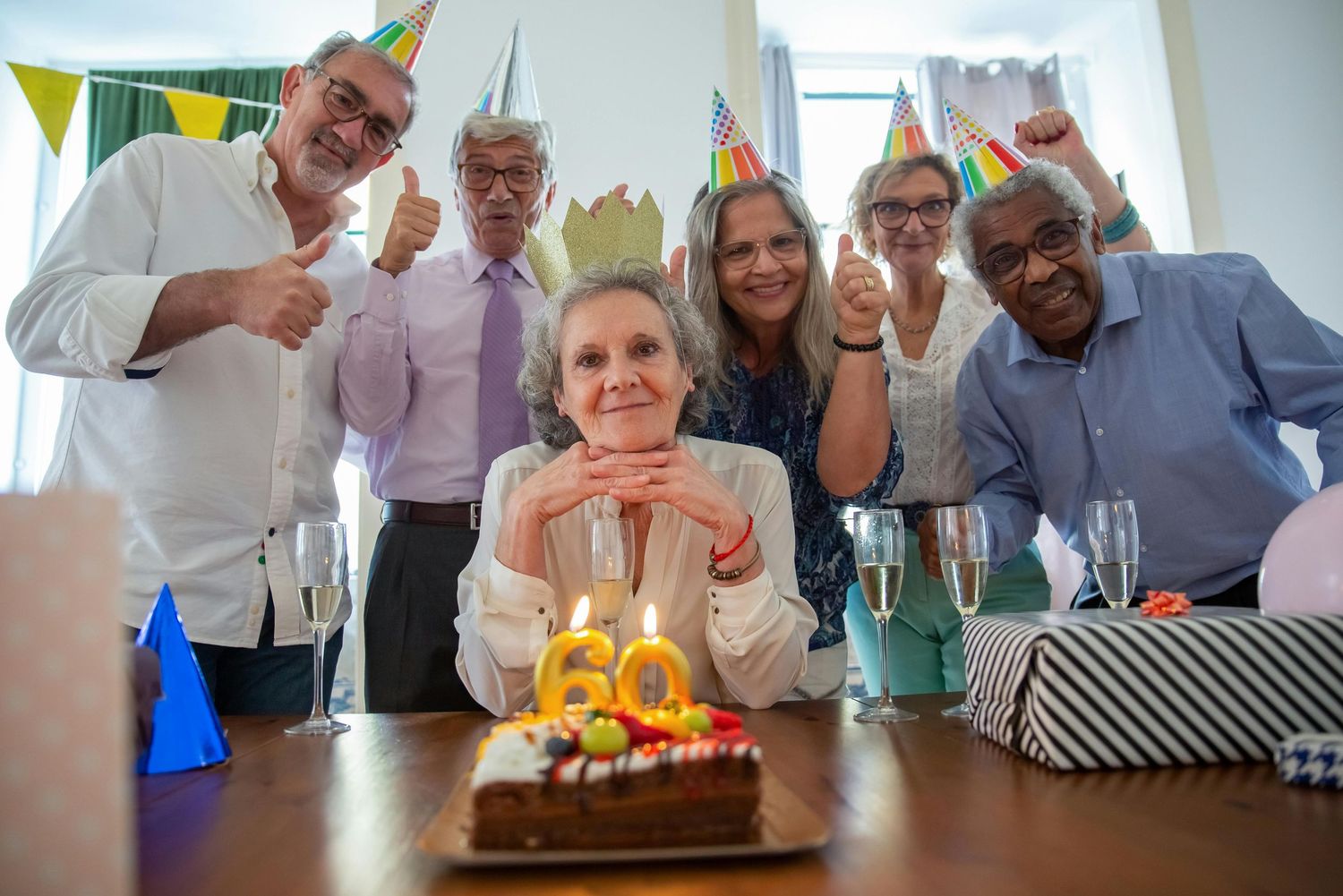 Best photogrpaher Peyson. People gathered around a birthday cake with lit candles at a celebration party.