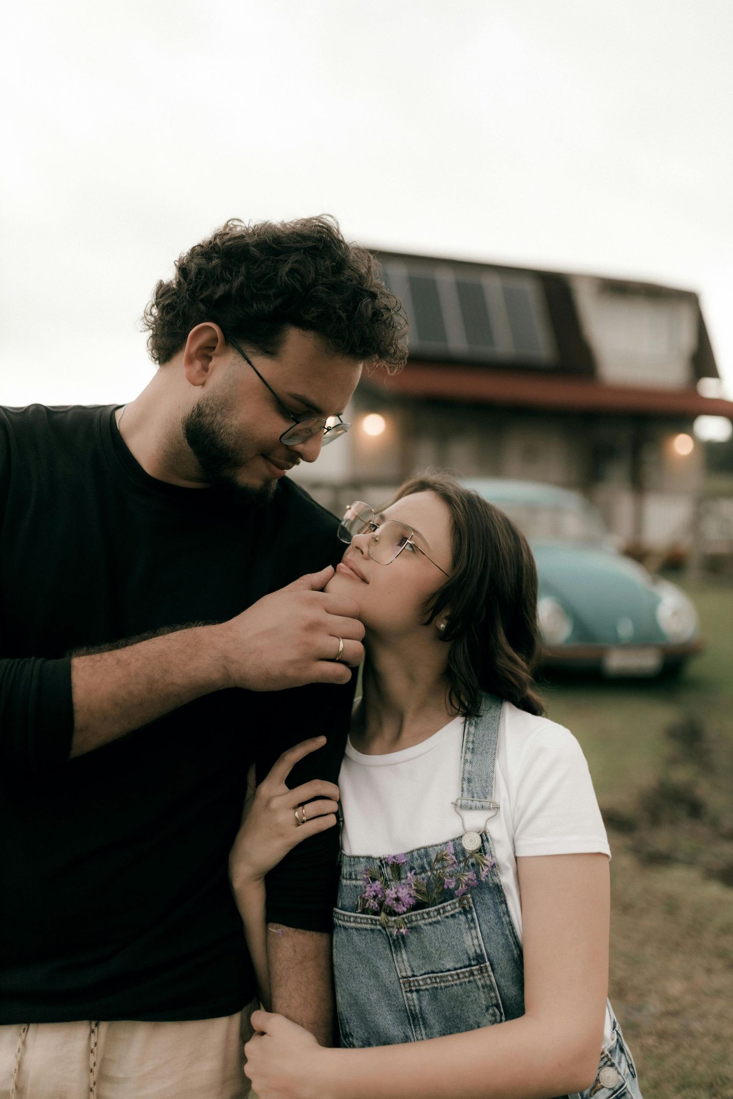 A tender romantic moment between a couple wearing glasses and denim overalls at sunset. Best Photographer Phoenix.