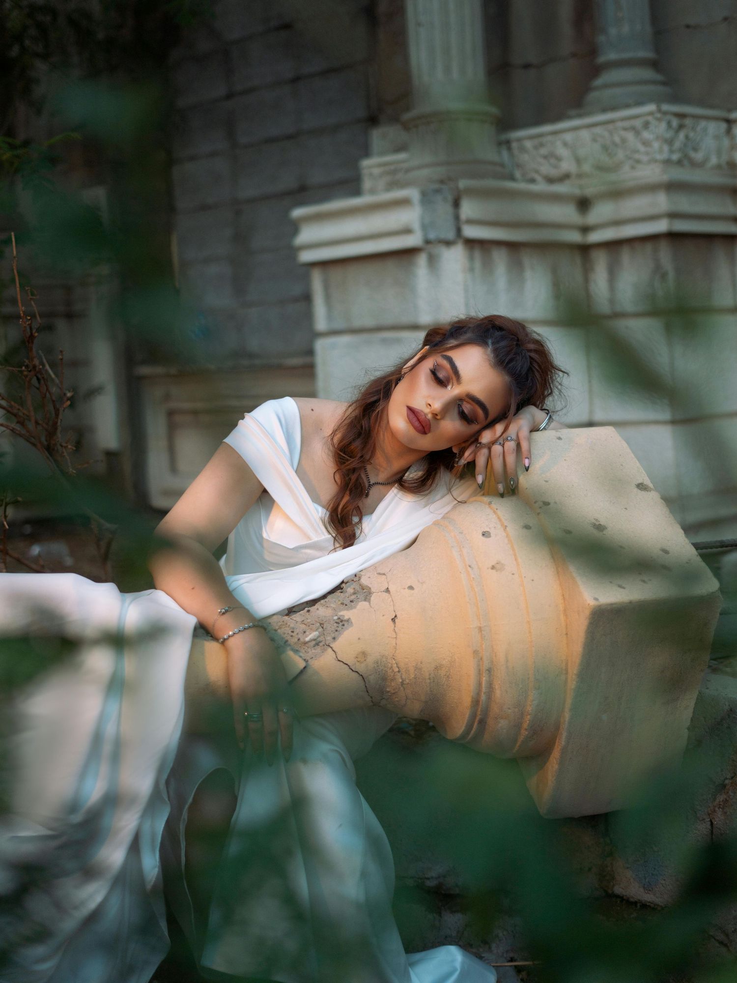 Artistic bridal portraits through foliage showing ethereal poses against a stone building backdrop.  Trusted Flagstaff Photographer.