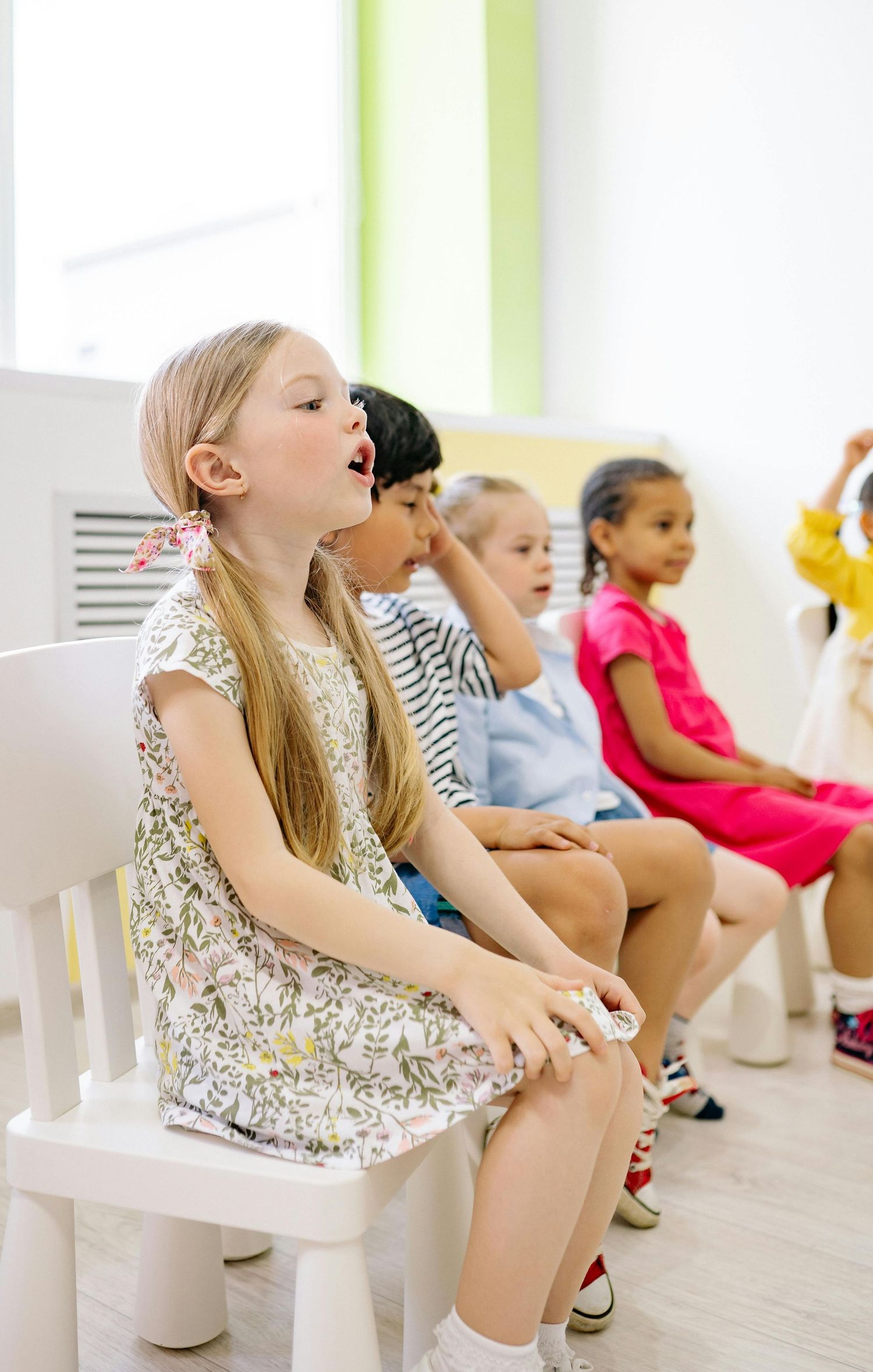 Queen Creek  Arizona Daycare Photography Students sitting in white chairs during a classroom learning session.