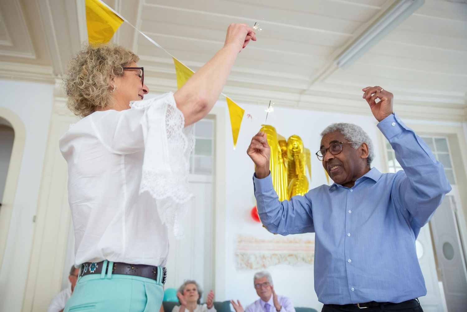 Premier Photographer Phoenix. Coworkers dance and celebrate under yellow bunting flags in a modern white office setting.