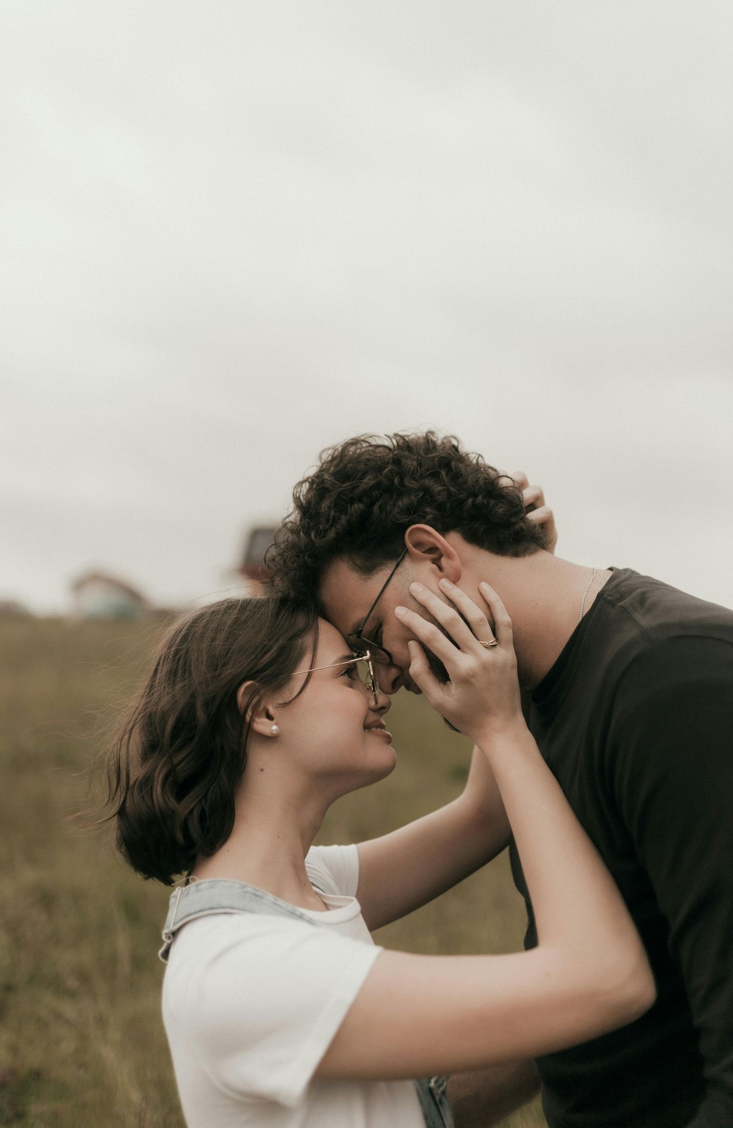 Romantic couple embraces in a tender moment against a moody outdoor backdrop. Best Photographer Phoenix.