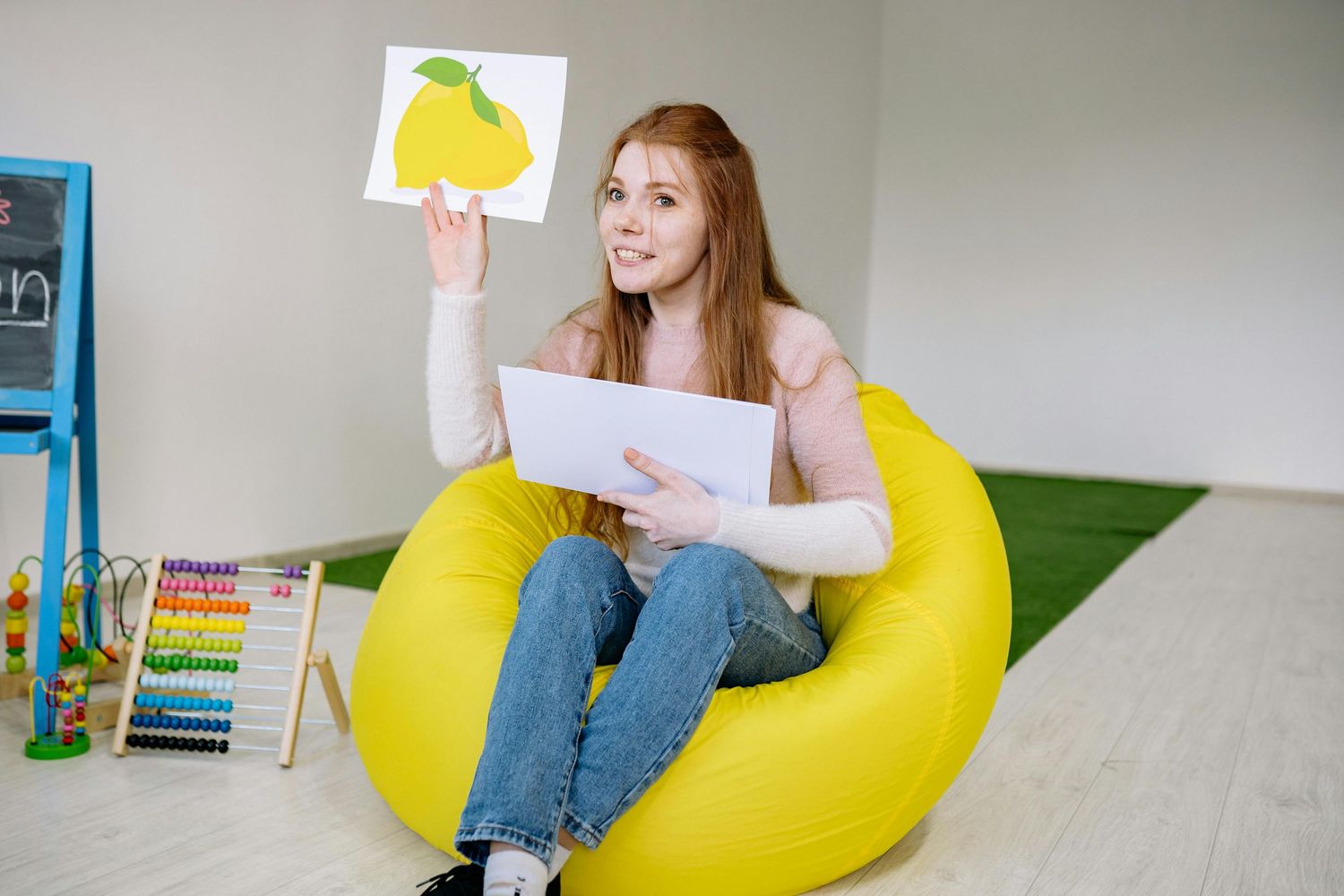 Queen Creek  Arizona Daycare Photography Student relaxes on a yellow bean bag chair in a classroom setting.