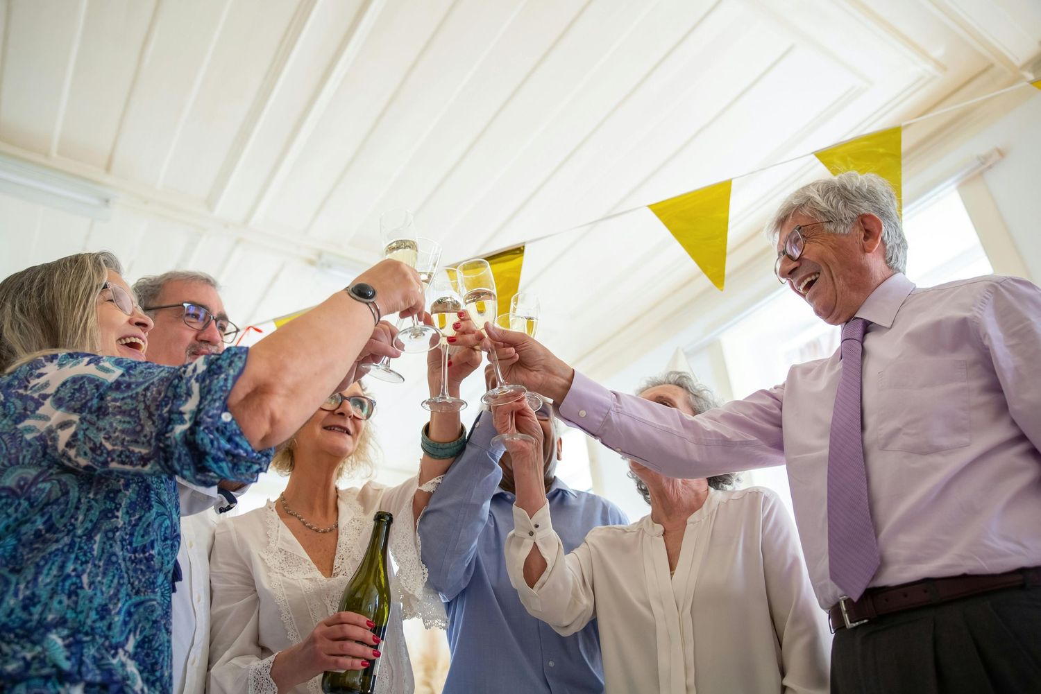Arizona Portrait Photographer. Elderly people enjoying drinks and socializing at a bright indoor gathering space with white decor.