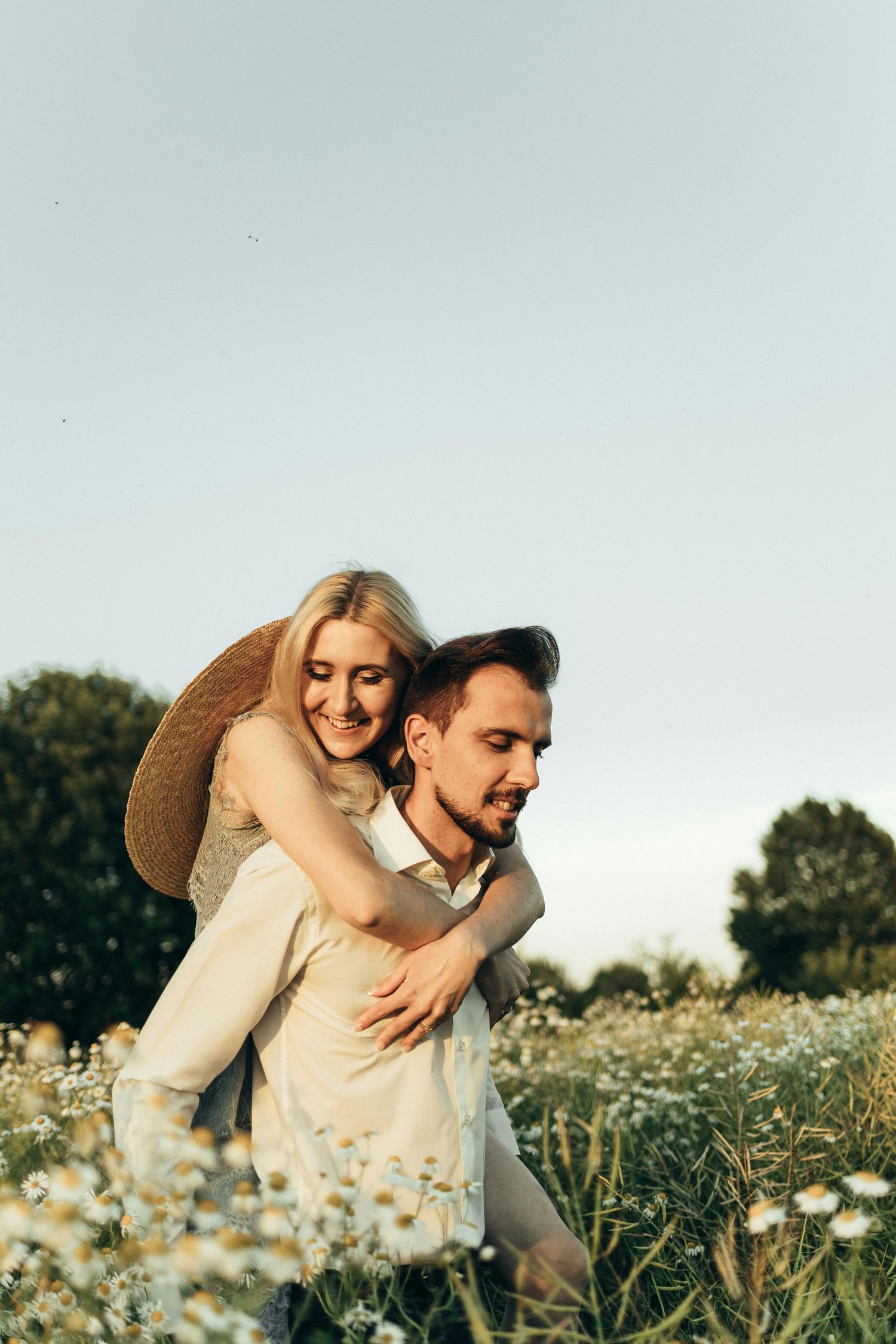 Intimate couple lying close in floral field, shown with romantic, warm desert-light photography. Fountain Hills.