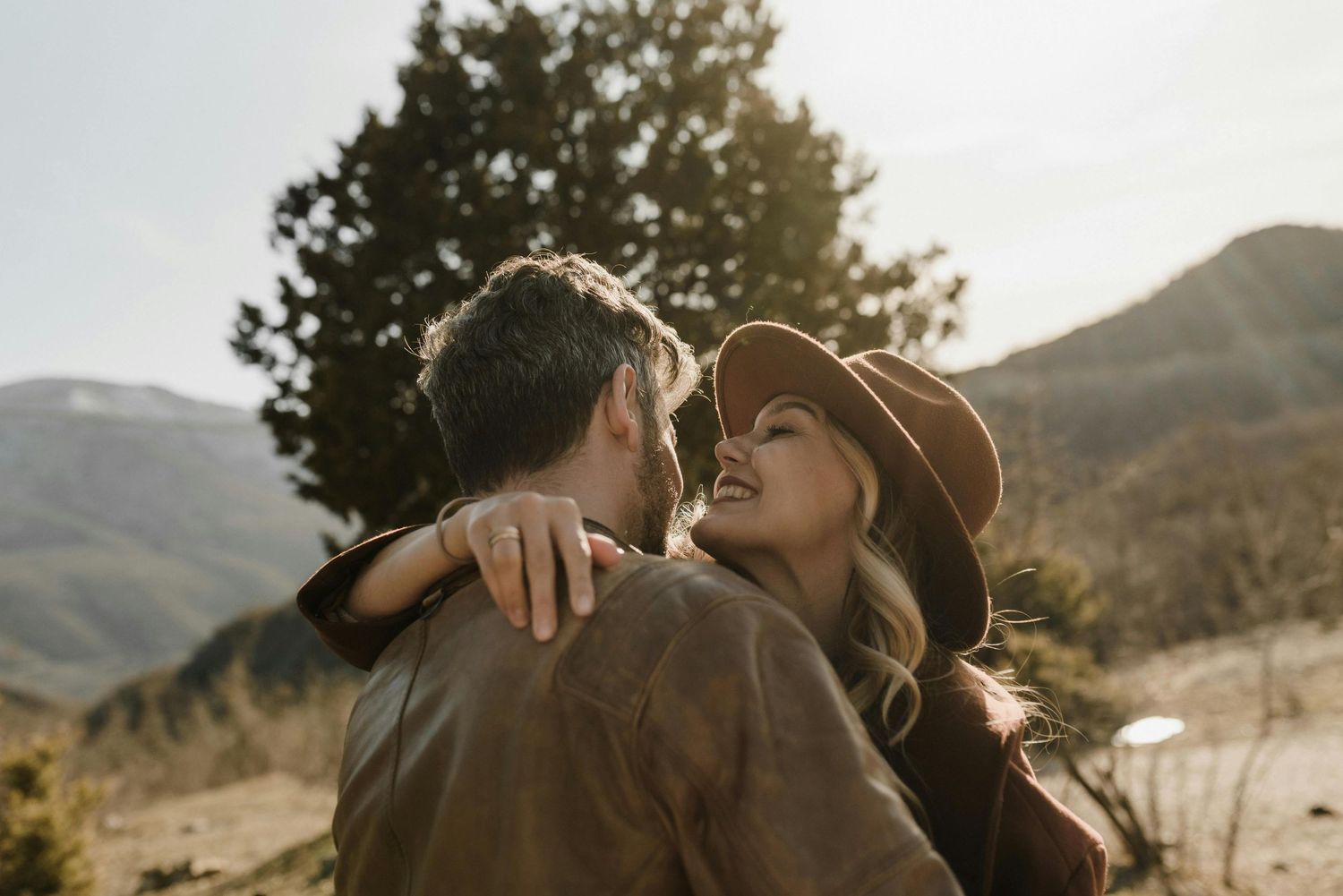 Tucson canyon sunset proposal, red-hatted woman glowing, intimate couple, photographed by top Arizona engagement photographer.