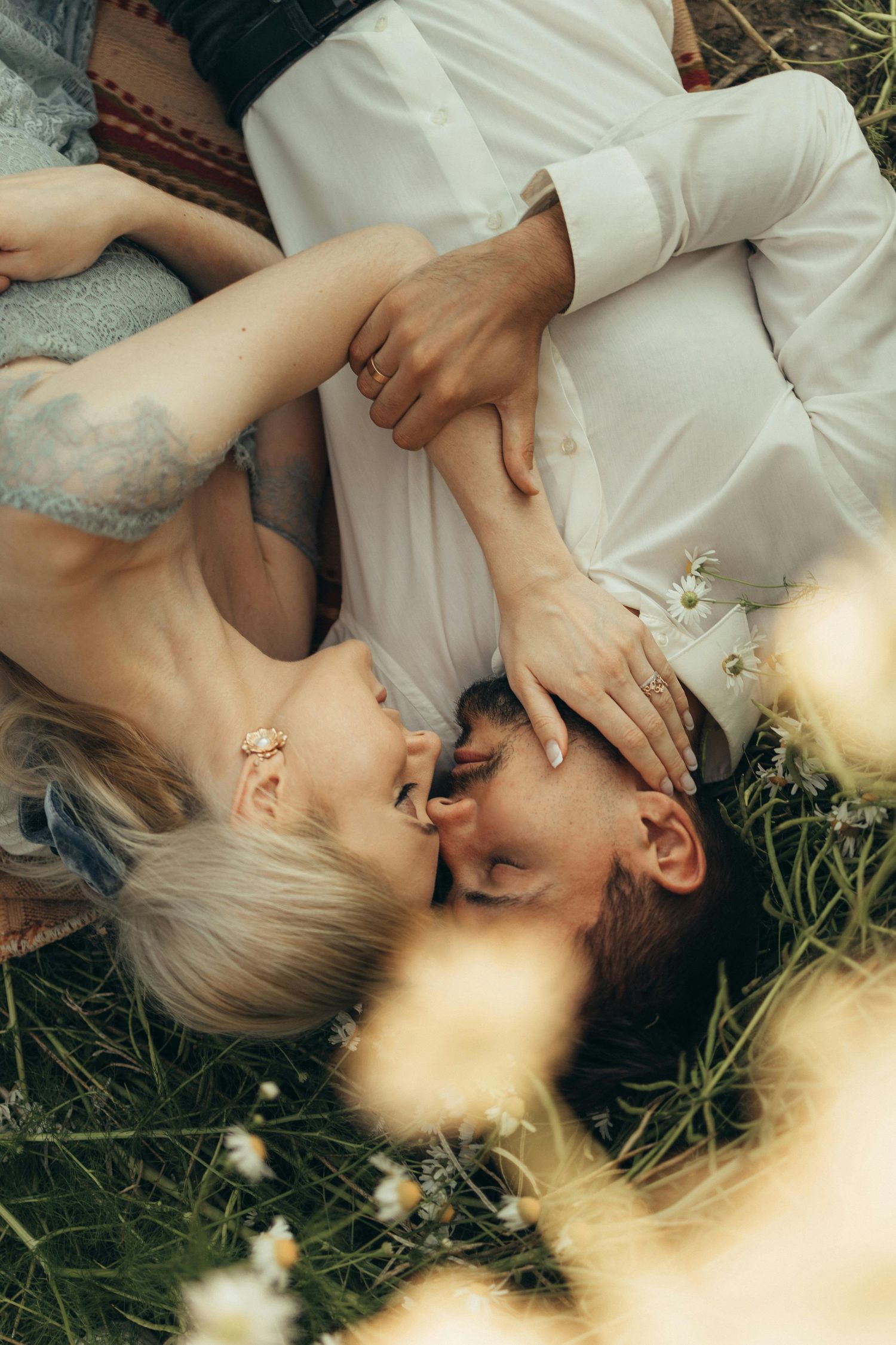 Couple lying in wildflowers sharing a tender moment with soft, romantic Arizona storytelling photography.