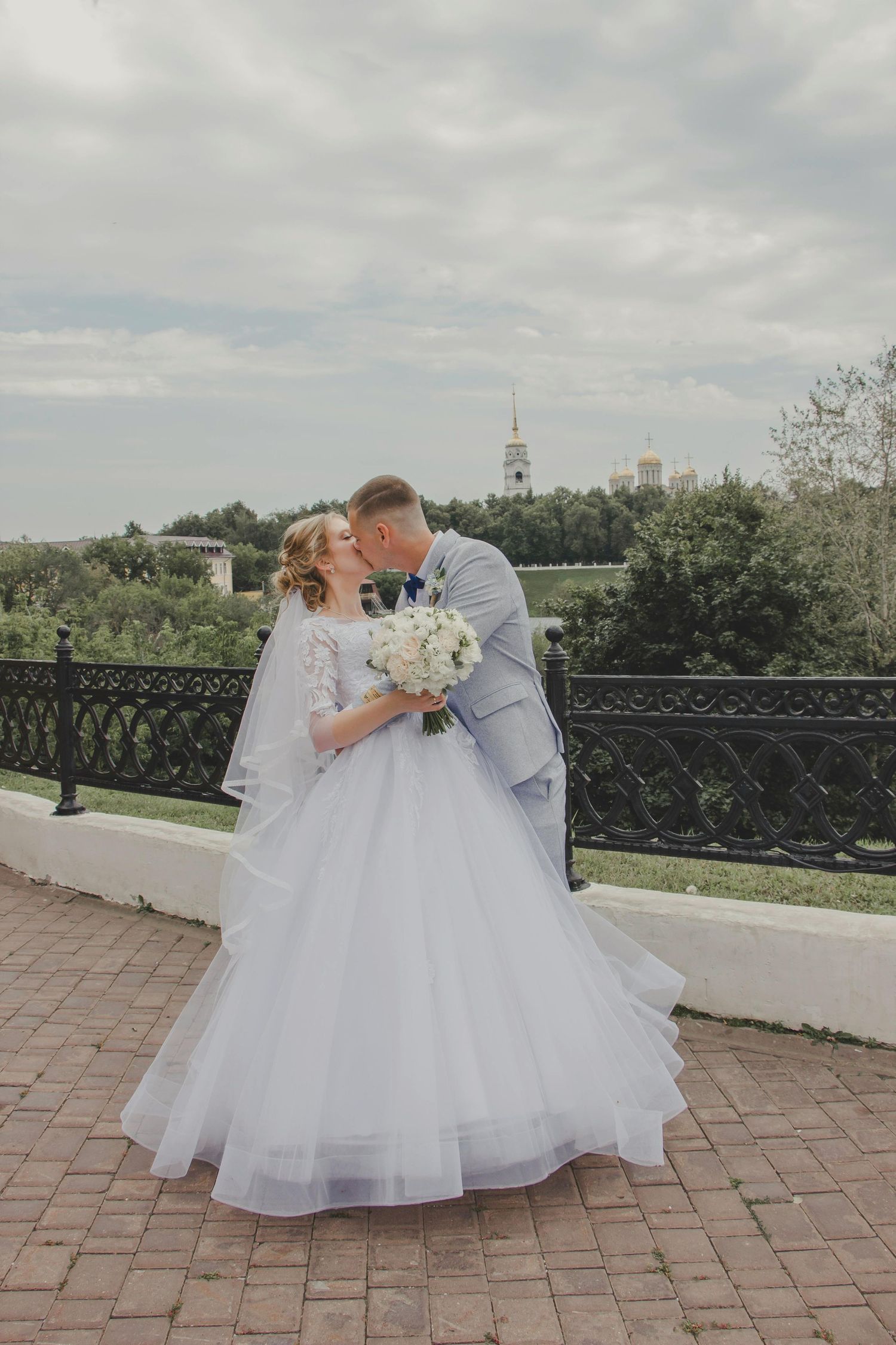 wedding couple shares intimate moments on brick terrace overlooking a scenic landscape . Trusted Sedona Photographer.